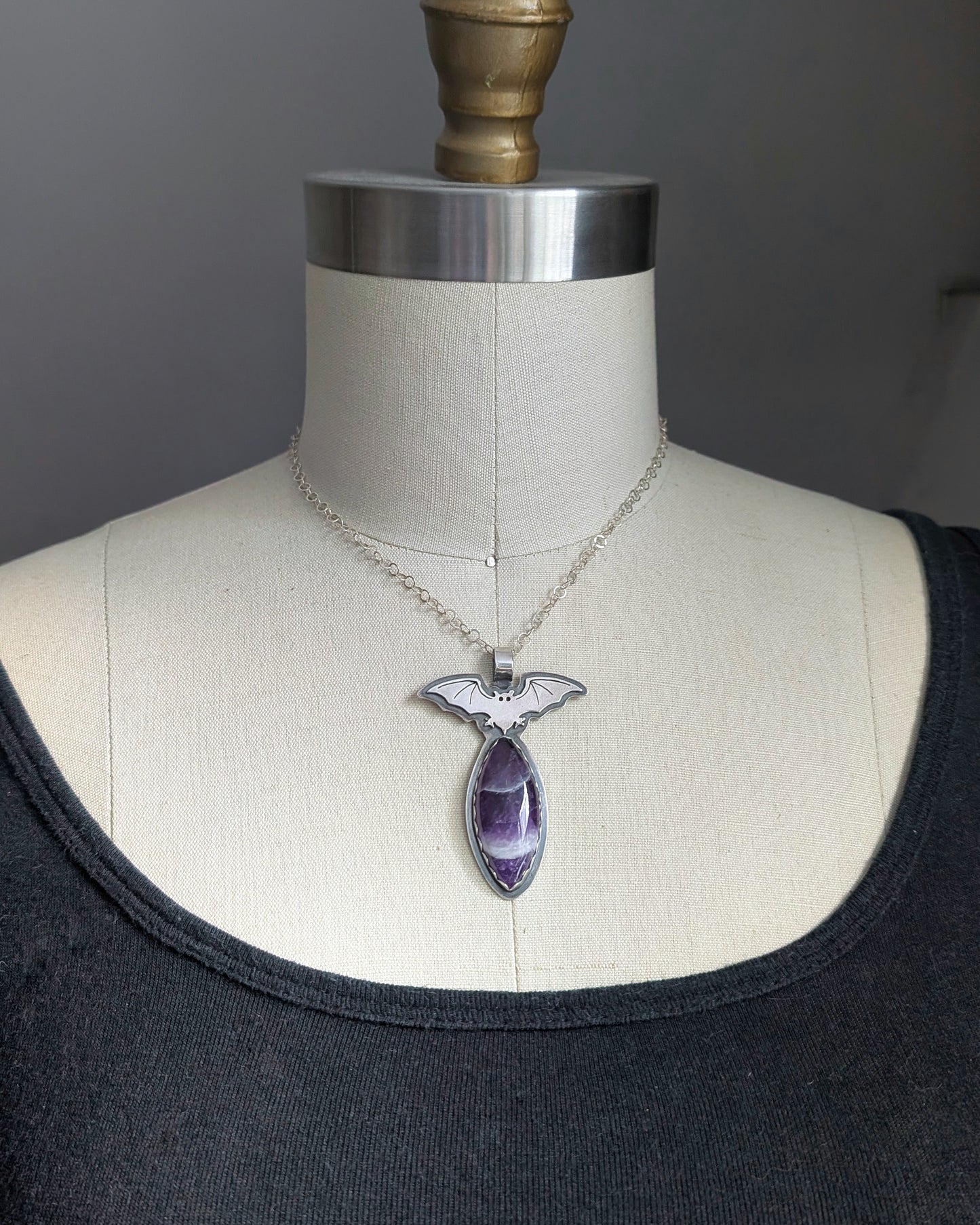 Sterling silver bat necklace with chevron amethyst on mannequin