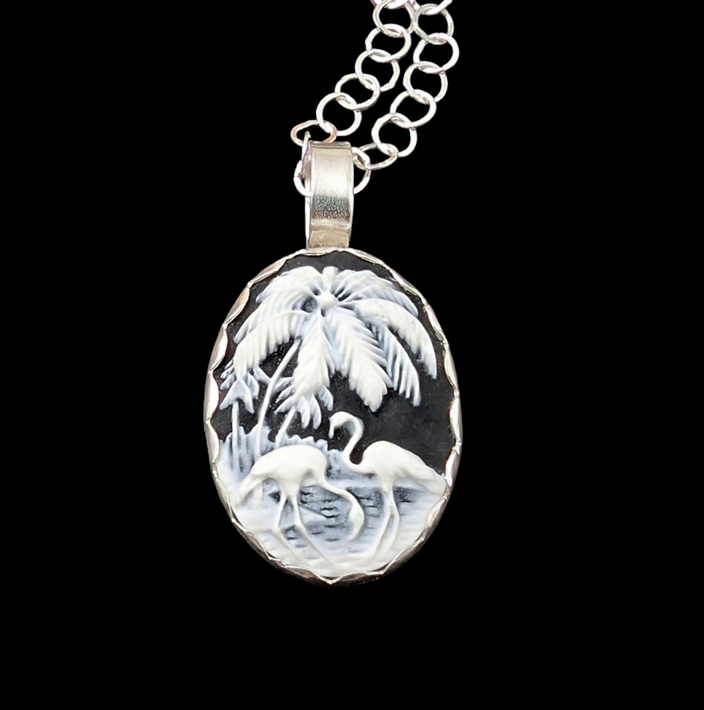 Black and white flamingo cameo Tiki necklace handmade in sterling silver shown on a black background