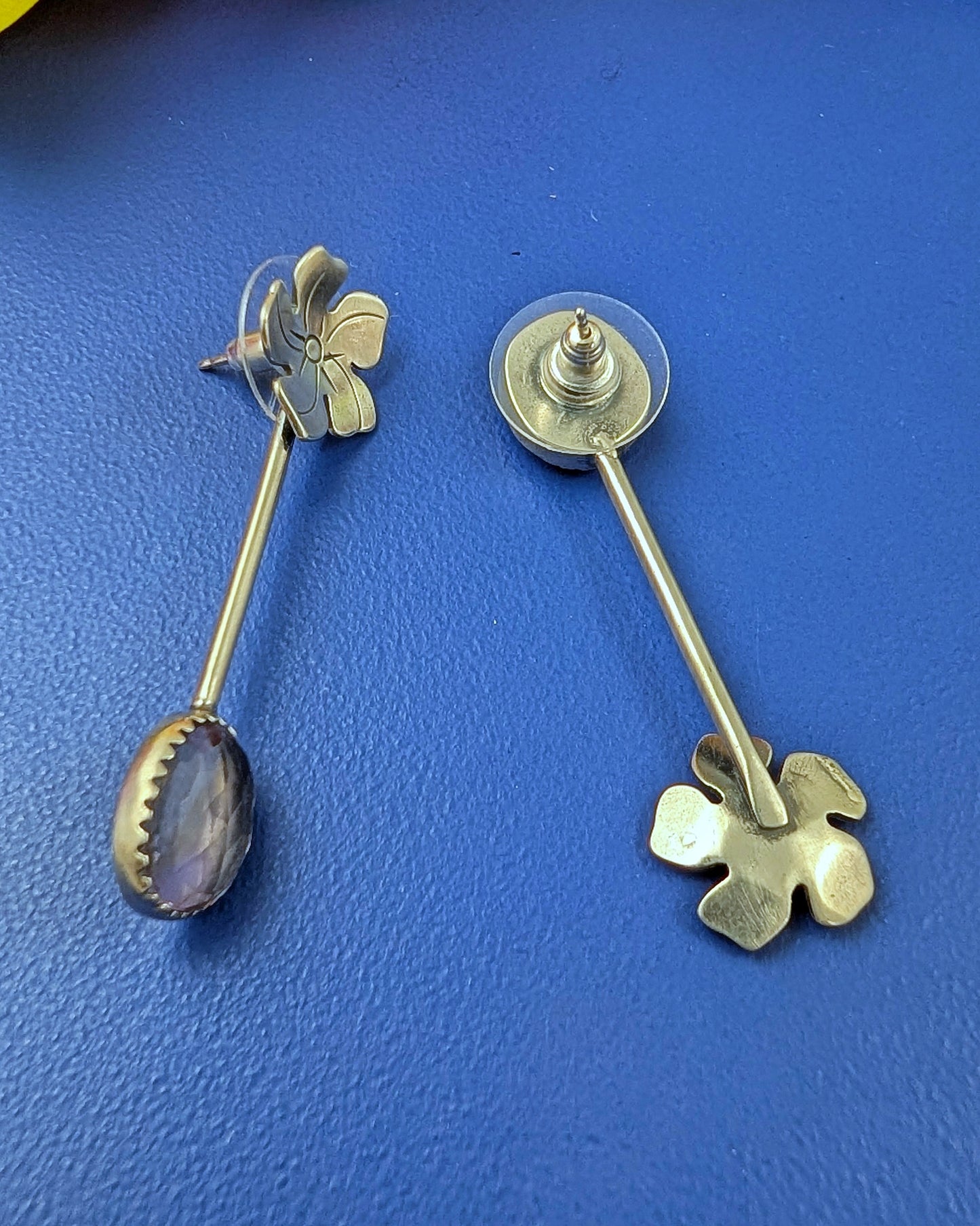 Sterling silver flower and purple yellow ametrine drop earrings with posts on a blue background