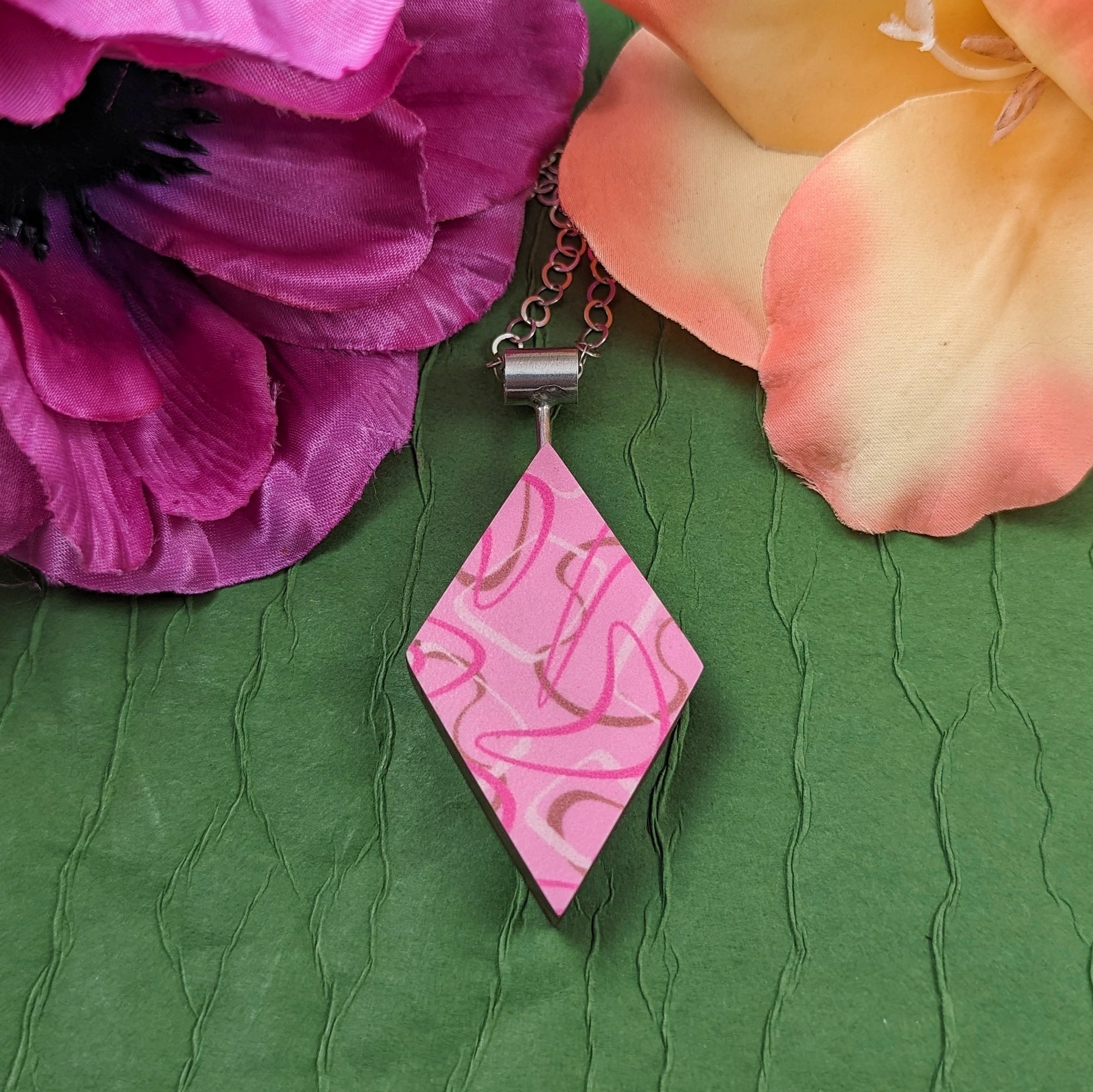 Pink boomerang laminate on wood diamond shaped necklace with a mid century modern vibe