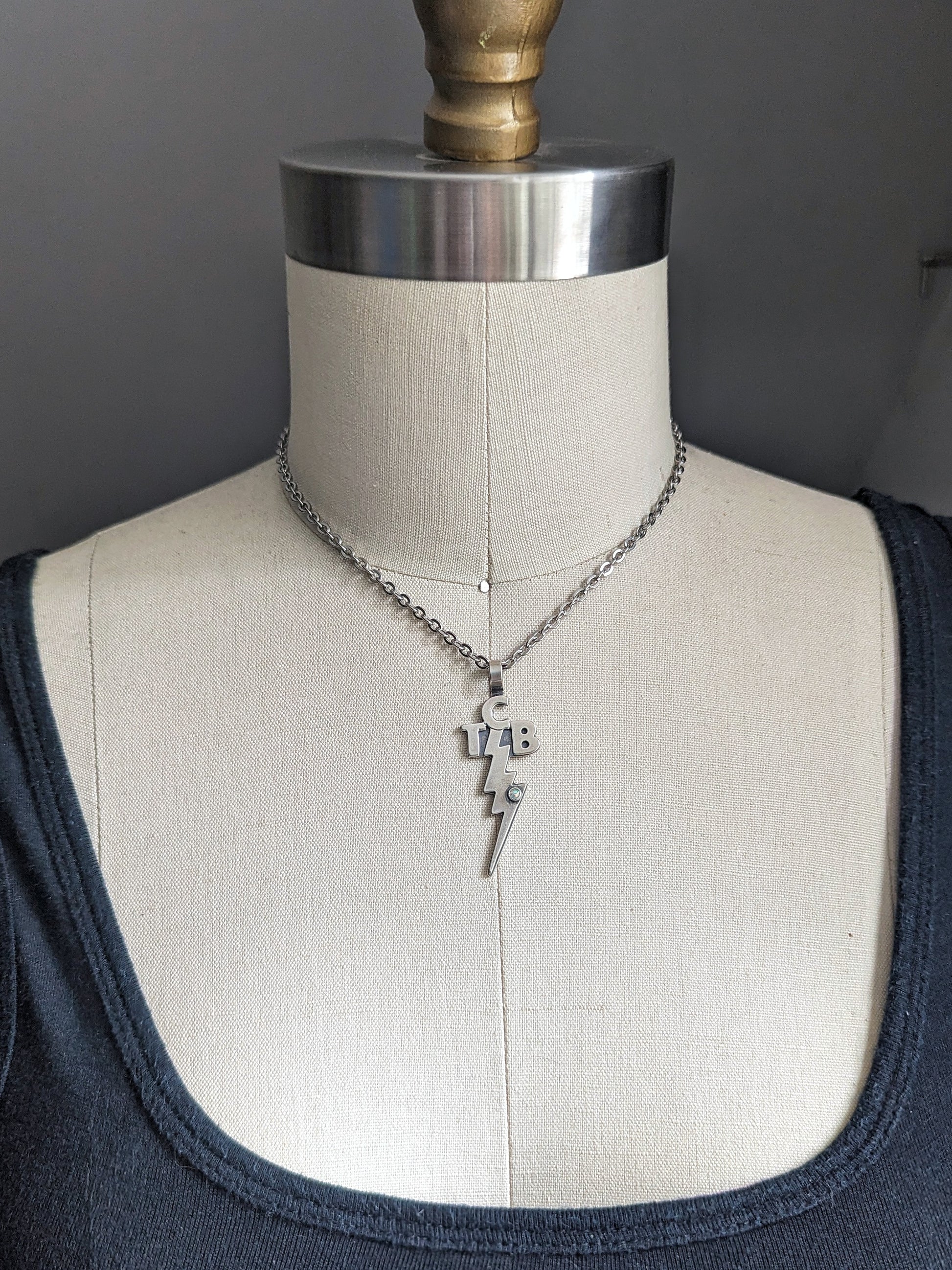 Elvis necklace showing TCB on bust