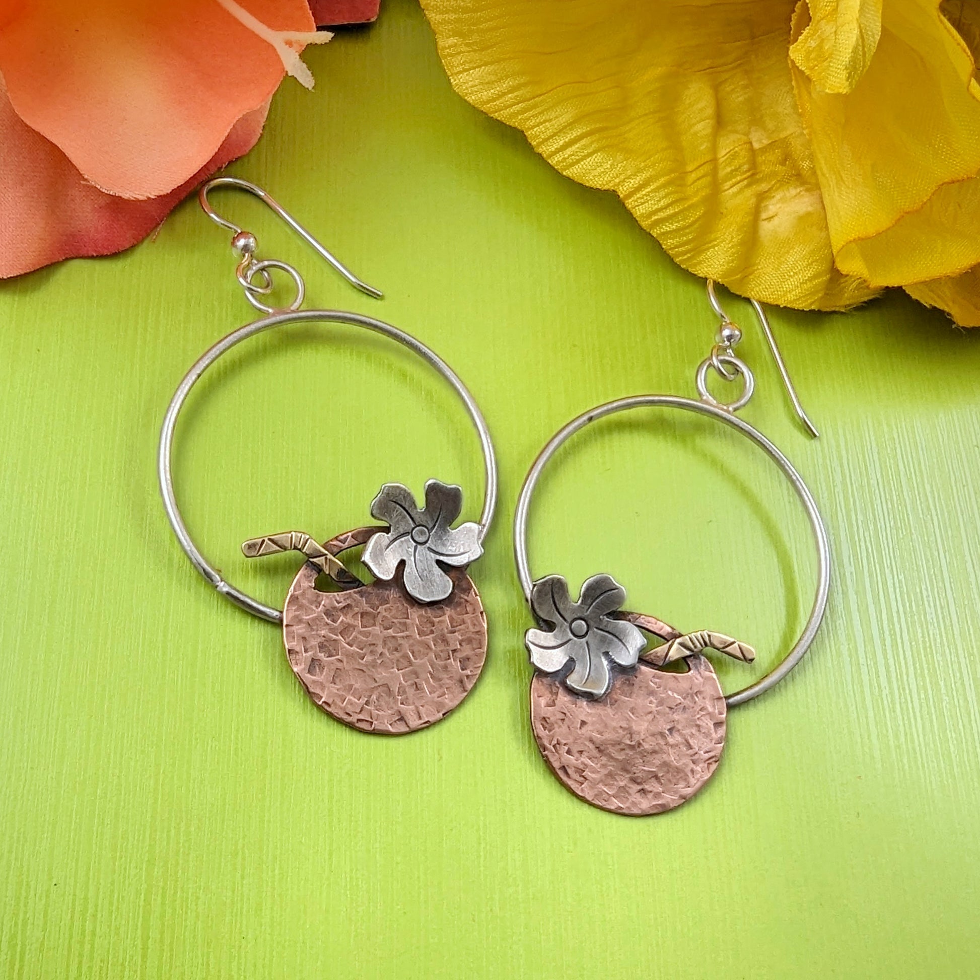 Hammered copper coconut earrings on sterling silver circles shown on green background