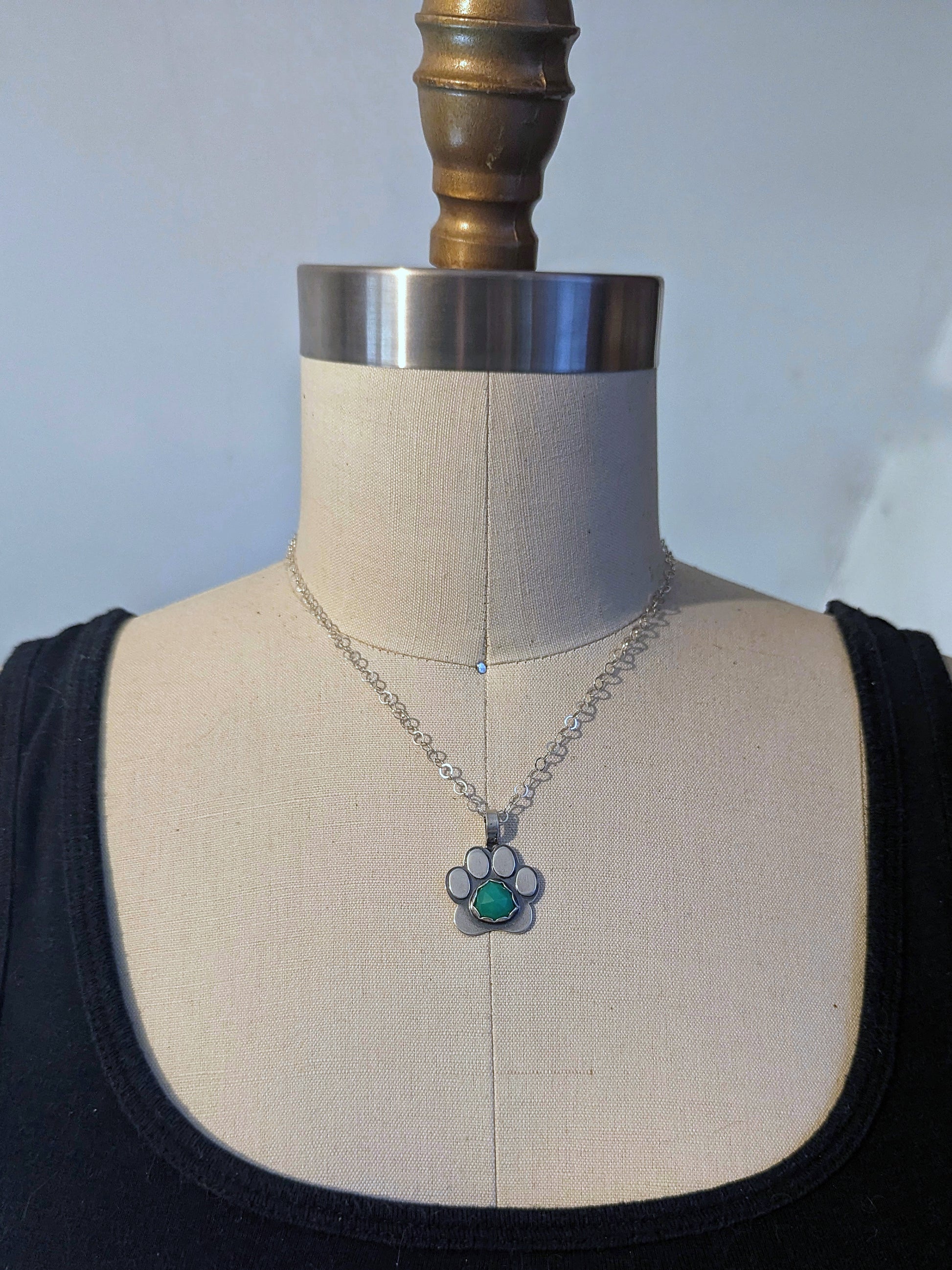 Sterling silver paw print necklace shown on dress form