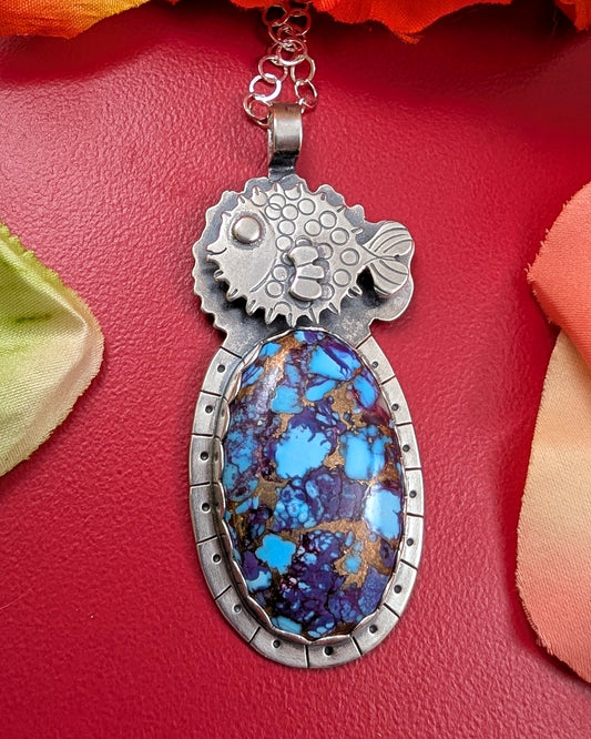 Puffer fish necklace with purple copper turquoise stone on red background with flowers