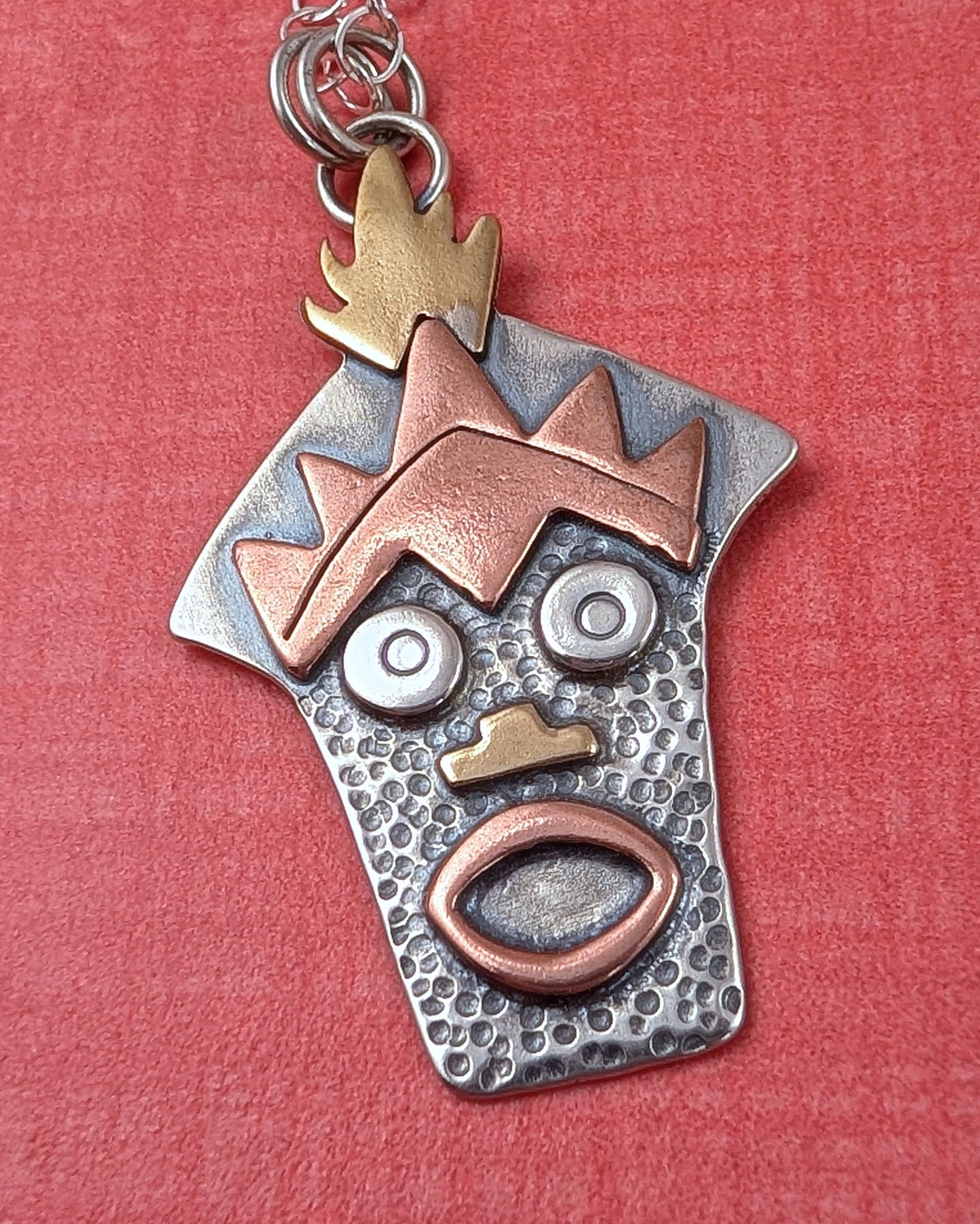 Sterling silver Witch Doctor with Hawaiian mask necklace on orange background