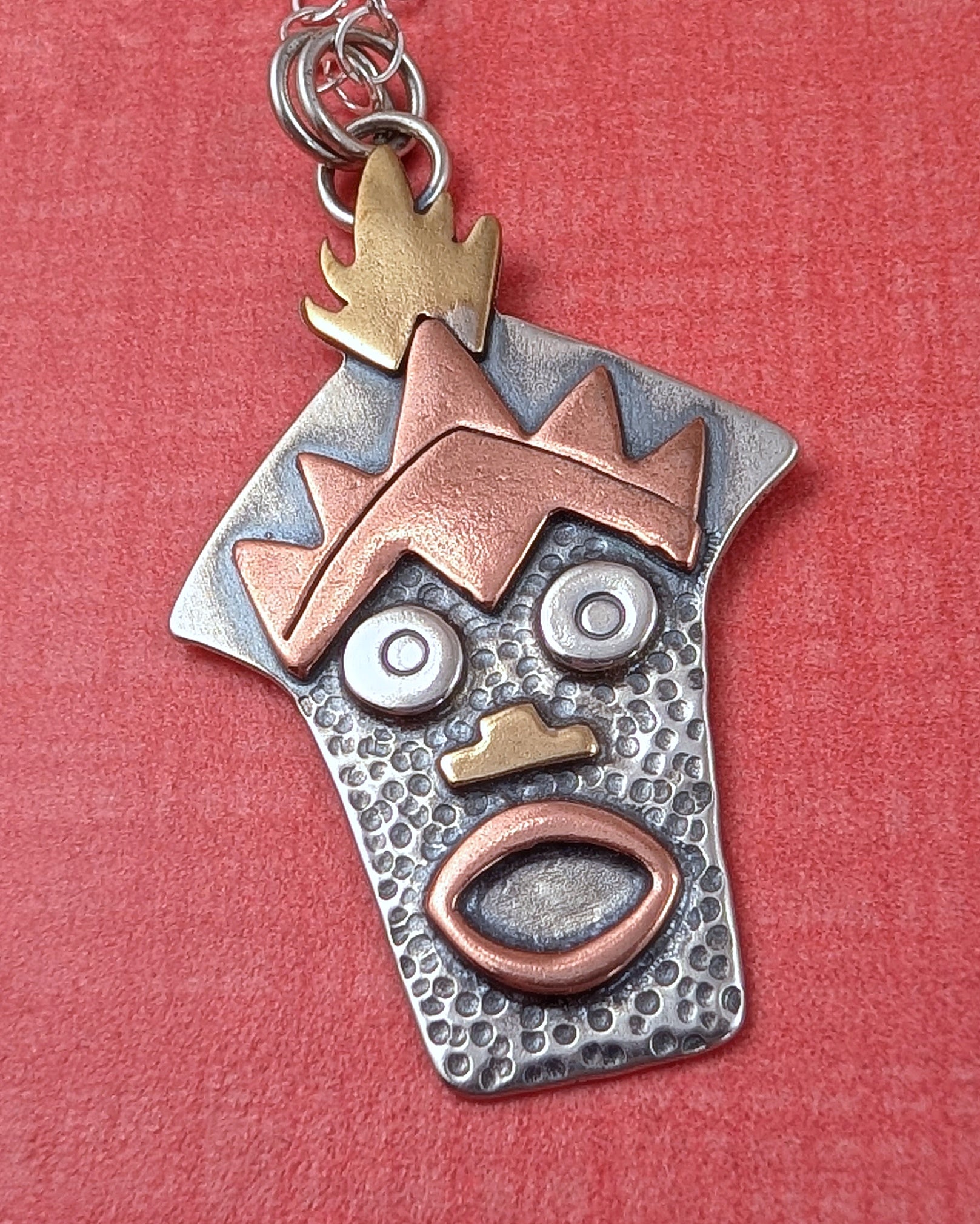 Sterling silver Witch Doctor with Hawaiian mask necklace on orange background