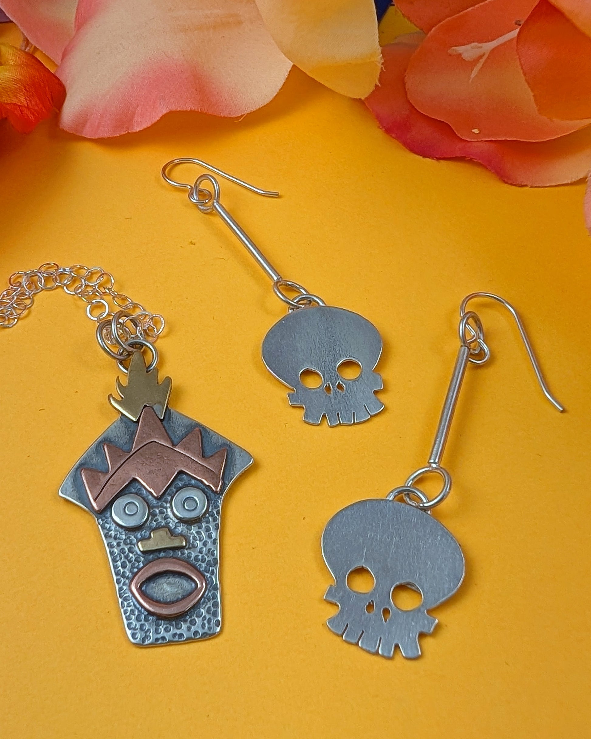 Witch Doctor with Hawaiian mask necklace and skull earrings on a yellow background