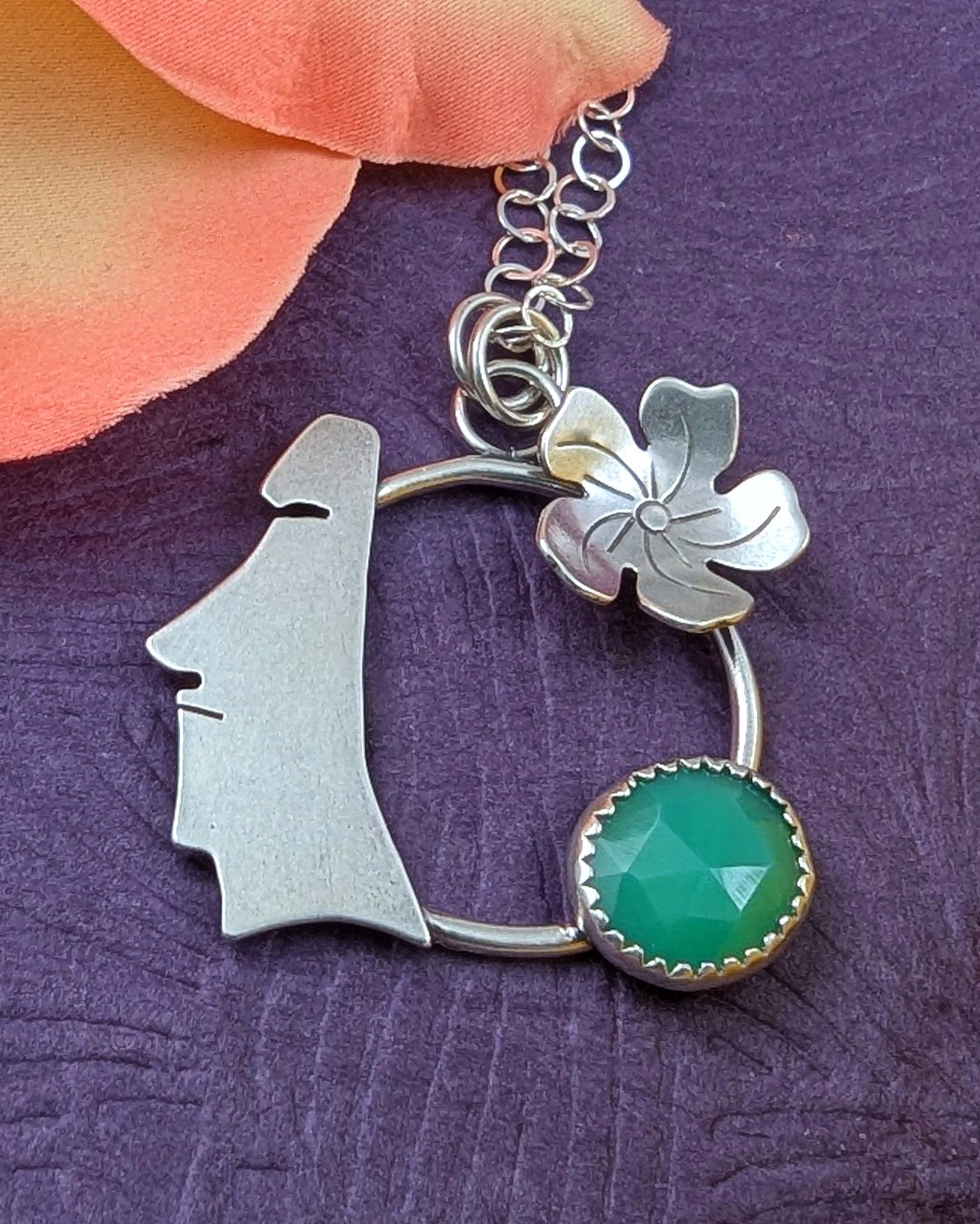 Sterling silver moai head necklace with green chalcedony on purple background