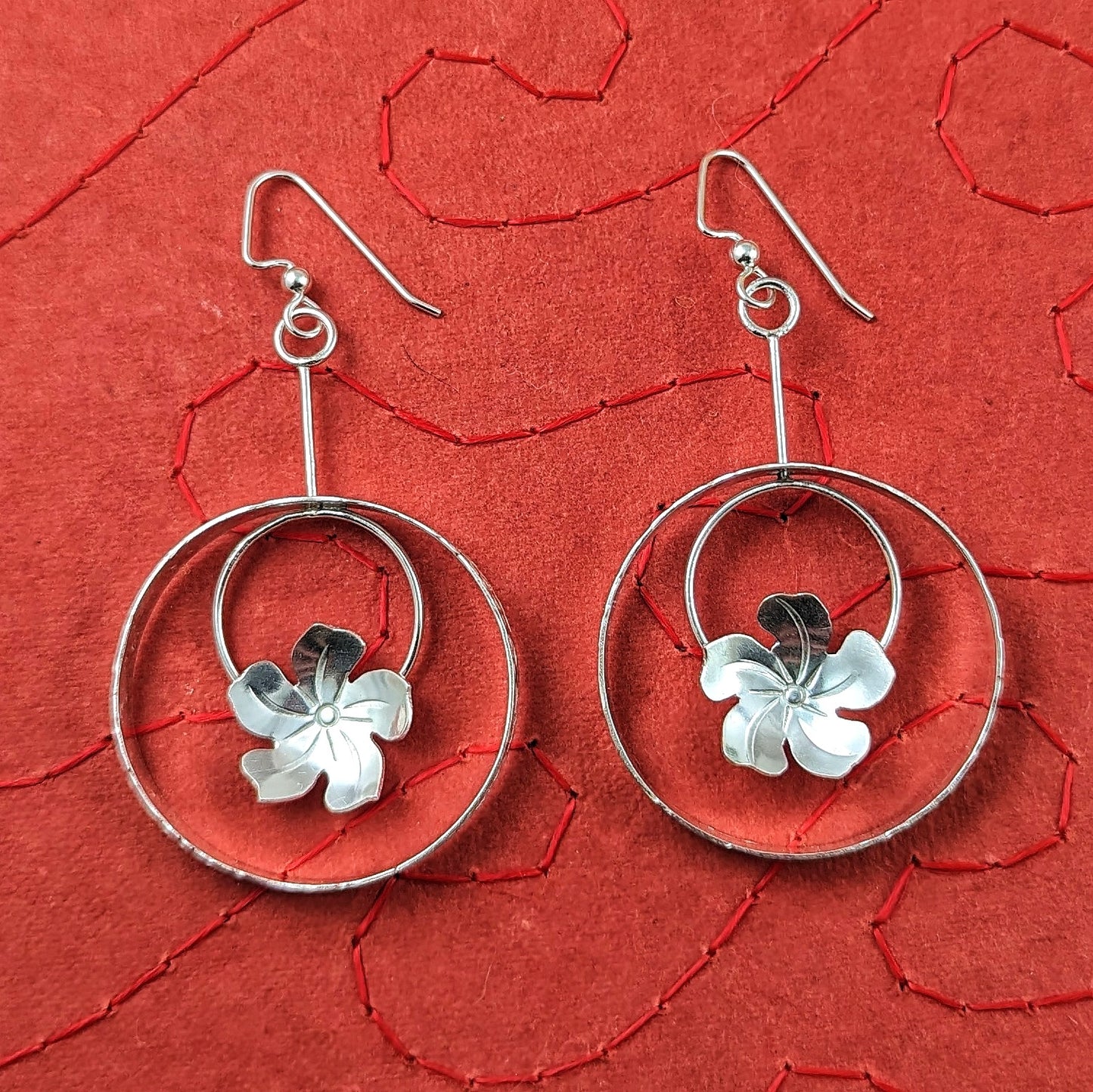 Handmade sterling silver plumeria flower in circle Tiki earrings