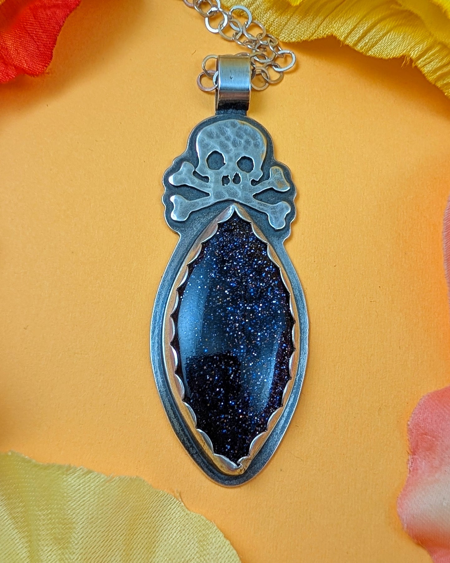 Blue goldstone with skull design on a yellow background