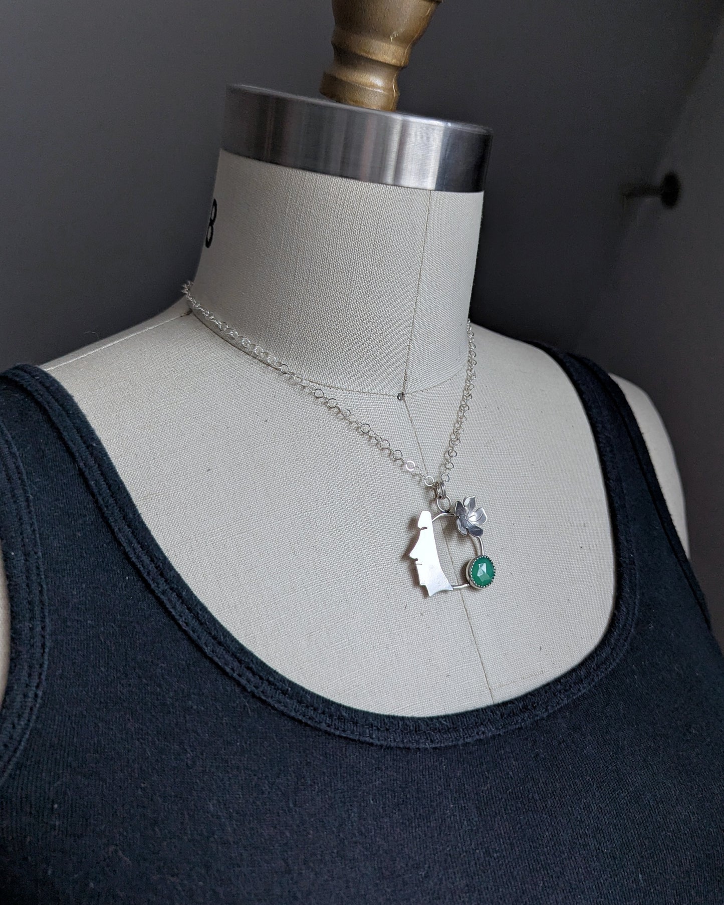 Side view on bust of moai necklace with green chalcedony