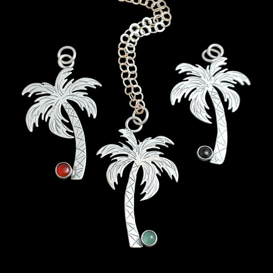 Handmade sterling silver palm tree necklaces with gemstone coconuts.