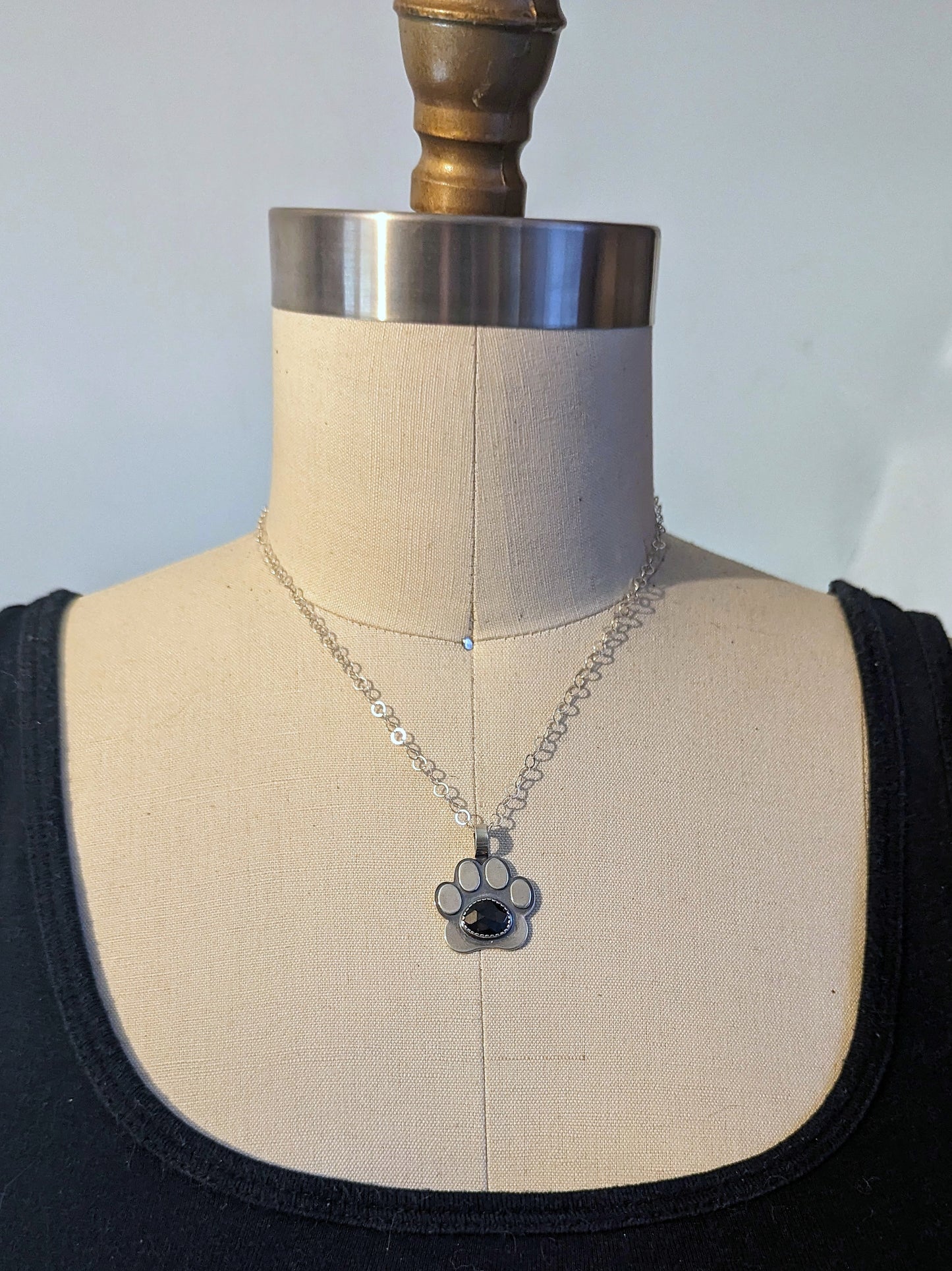 Sterling silver paw necklace shown on dress form