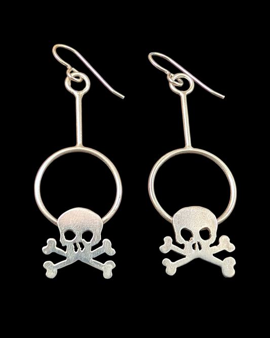 Silver skull and crossbones earrings on a black background