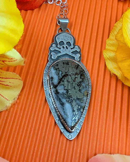 Sterling silver skull necklace with marcasite on an orange background
