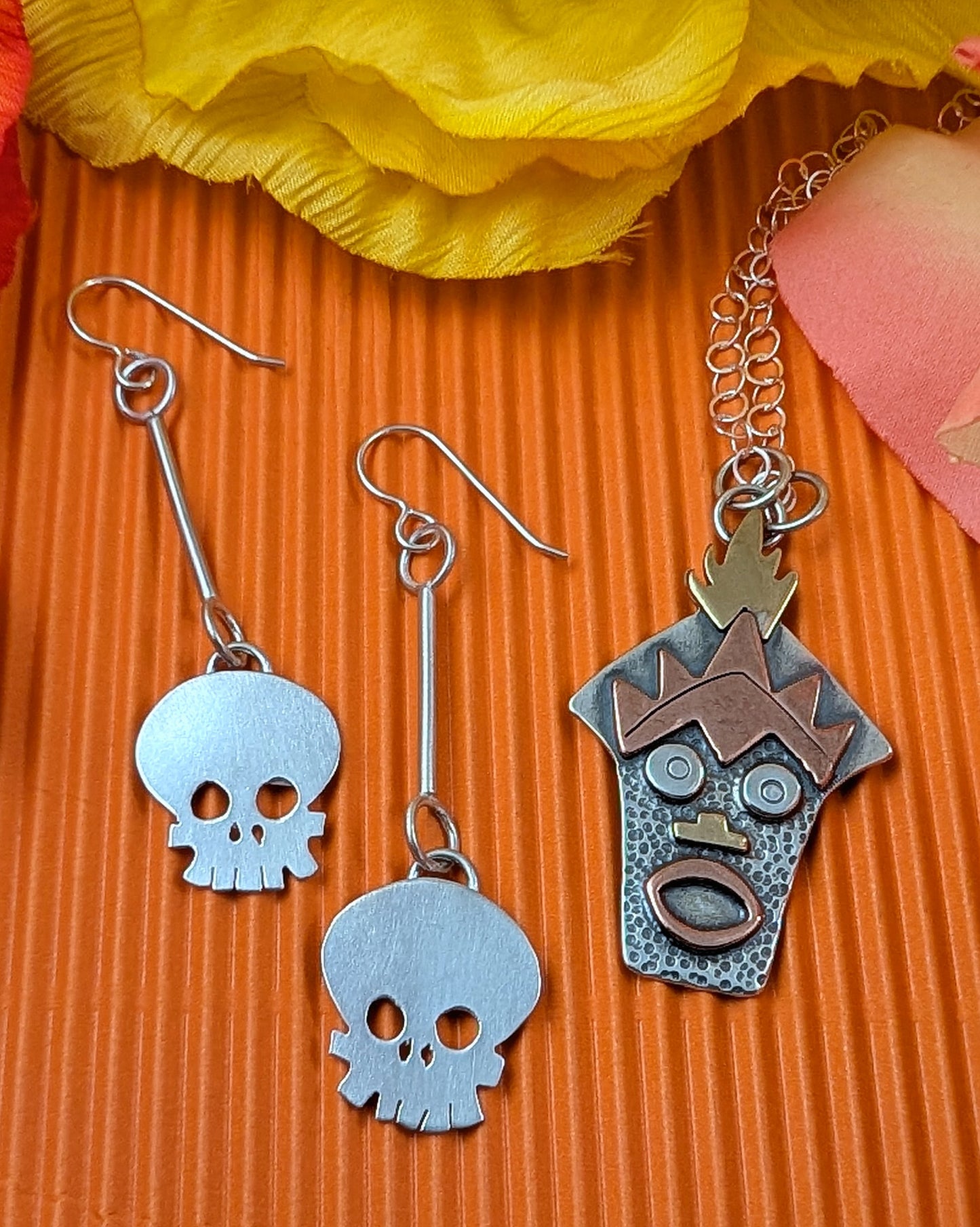 Witch Doctor with Hawaiian mask necklace and skull earrings on an orange background