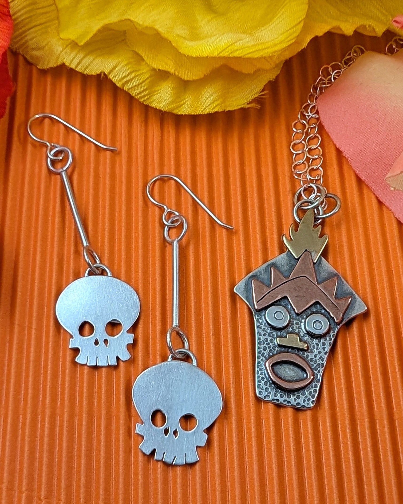 Witch Doctor with Hawaiian mask necklace and skull earrings on an orange background