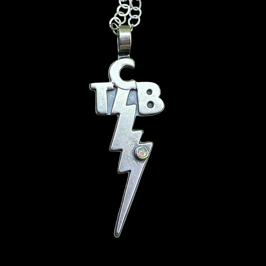 TCB sterling silver necklace on black background