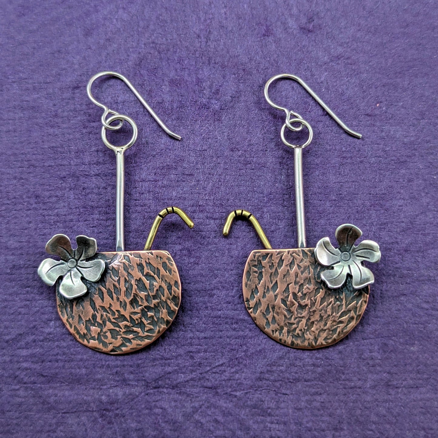 Copper coconut drop tropical earrings with brass straw and sterling silver flower on a purple background