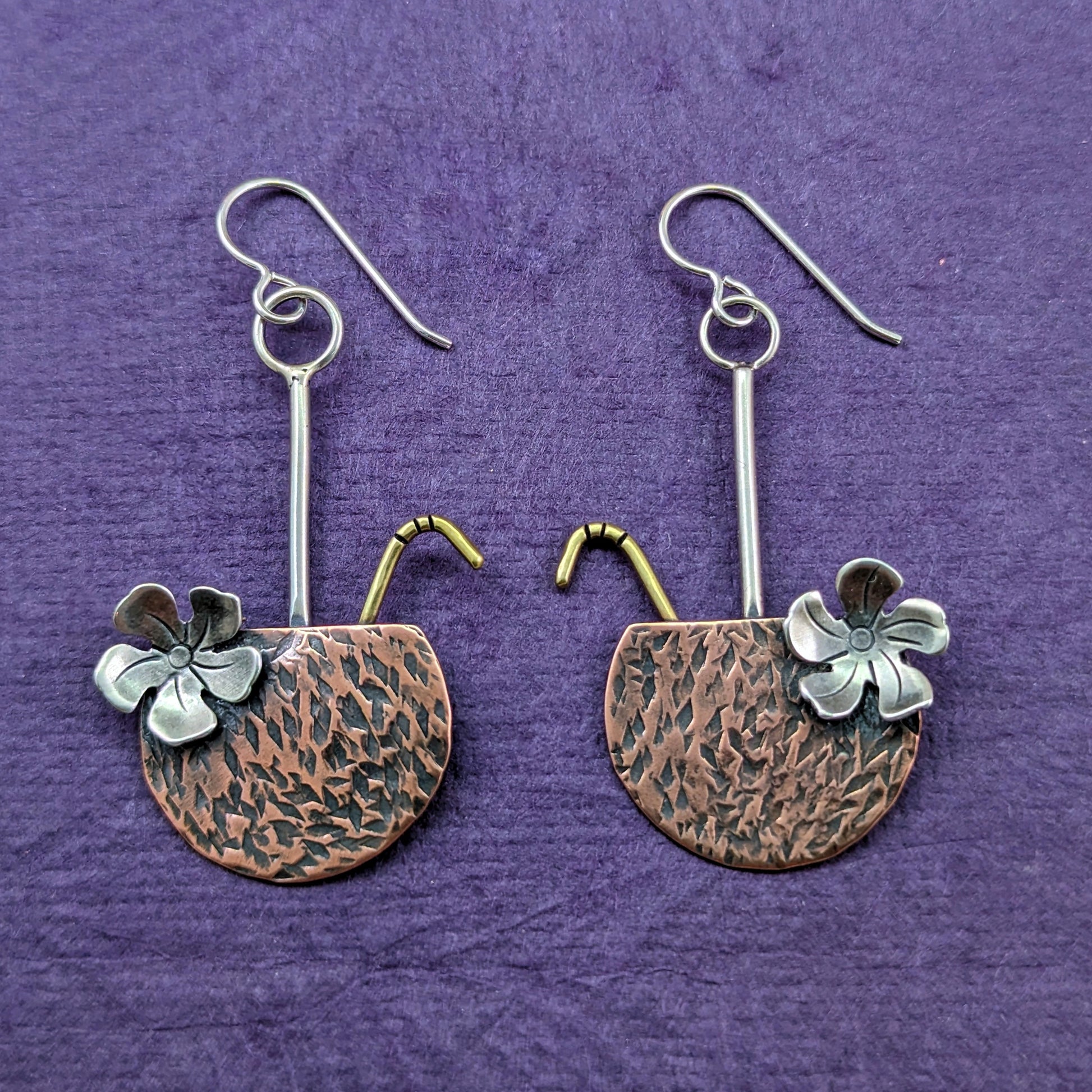 Copper coconut drop tropical earrings with brass straw and sterling silver flower on a purple background