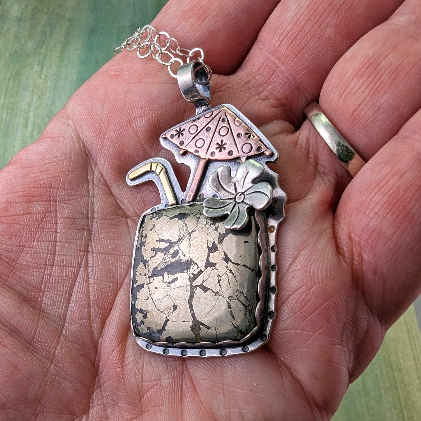 Marcasite tiki drink necklace shown in my hand