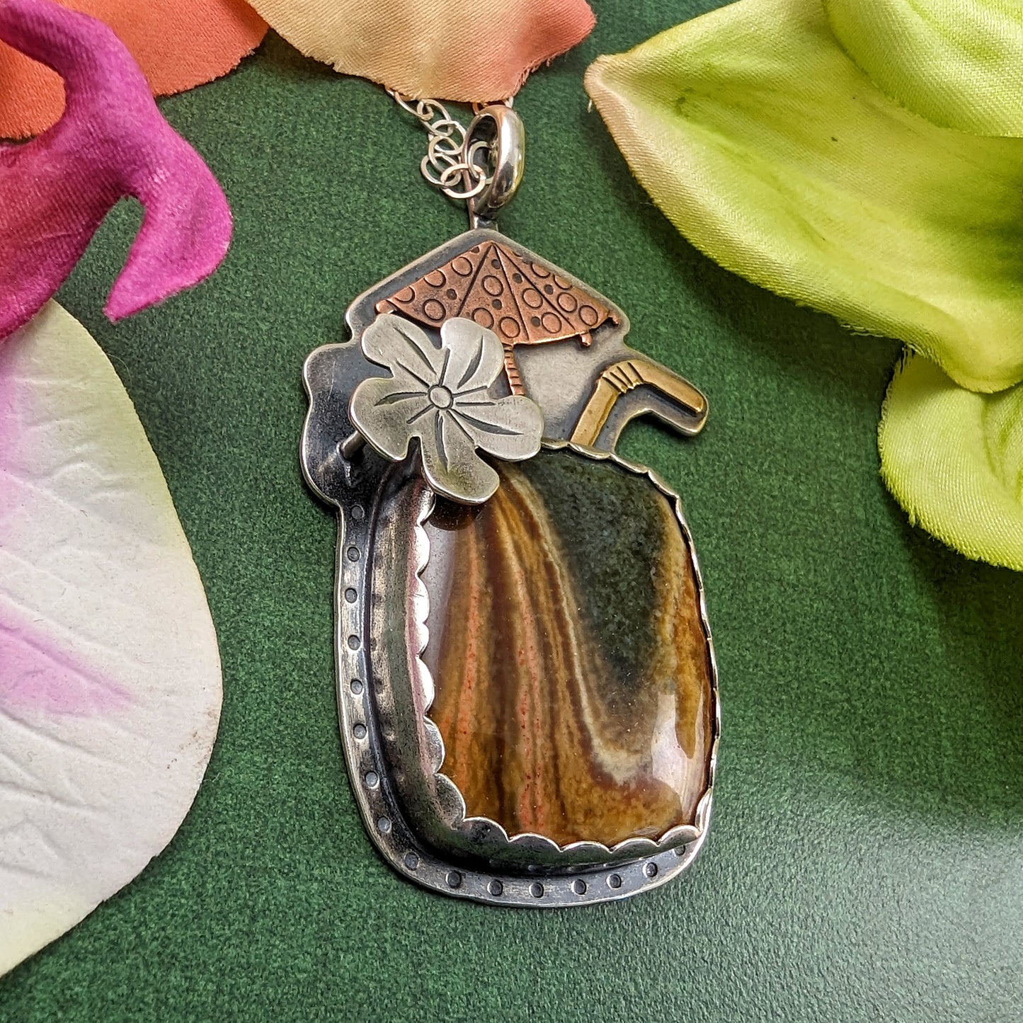 Tiki drink cocktail necklace on green background