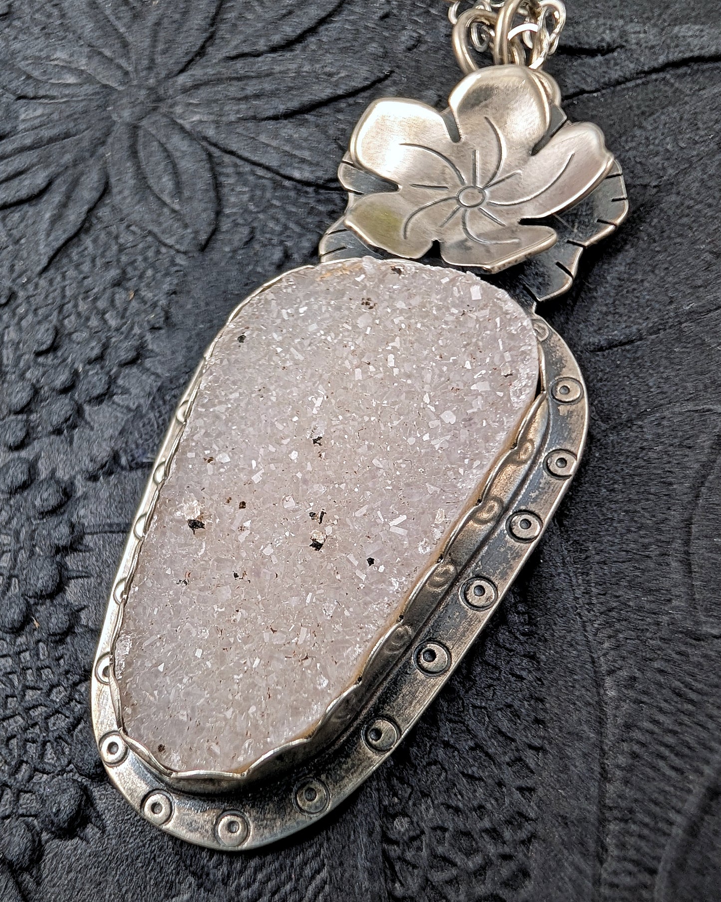 White druzy and flower necklace on a black background
