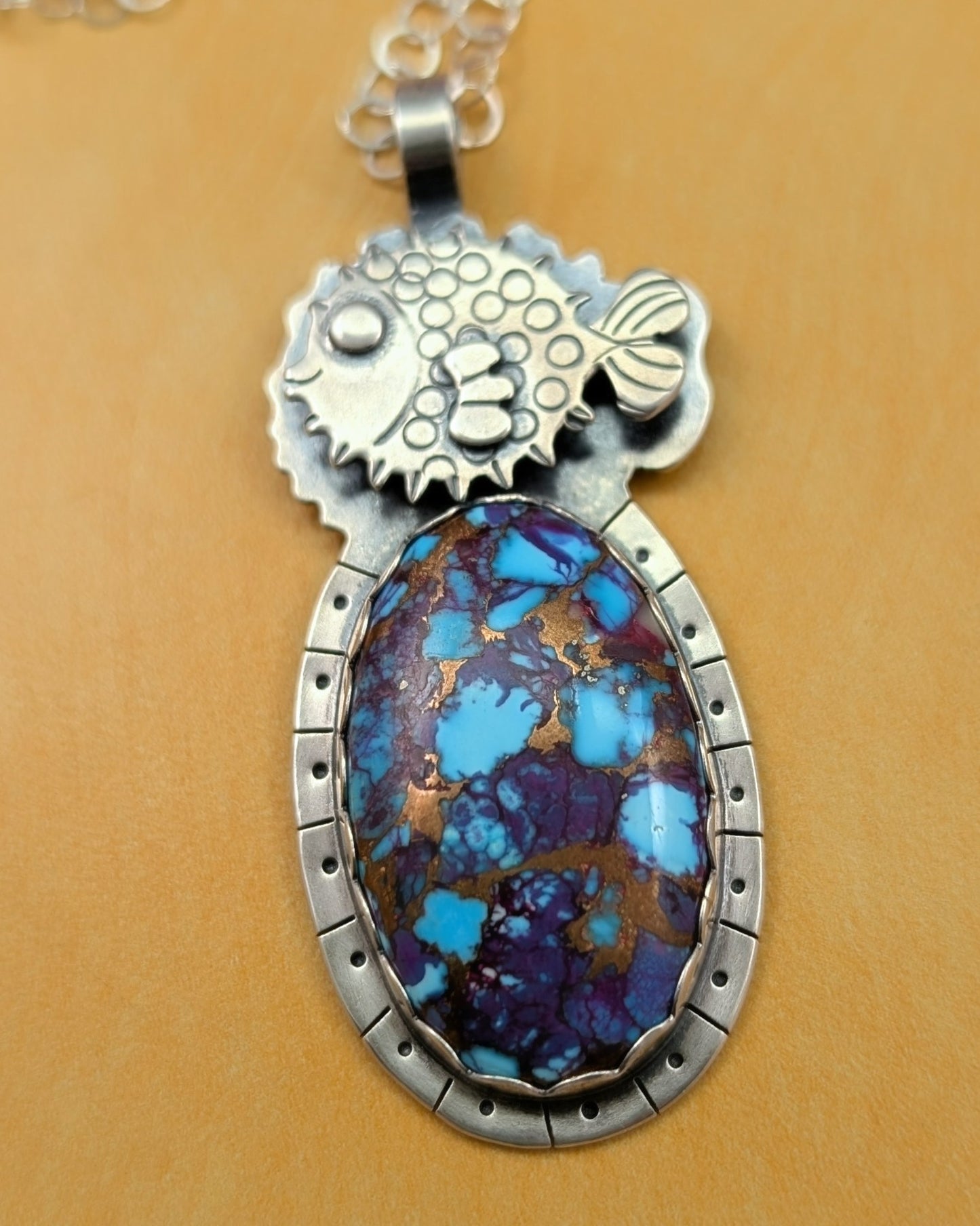 Puffer fish necklace with purple copper turquoise stone on yellow background