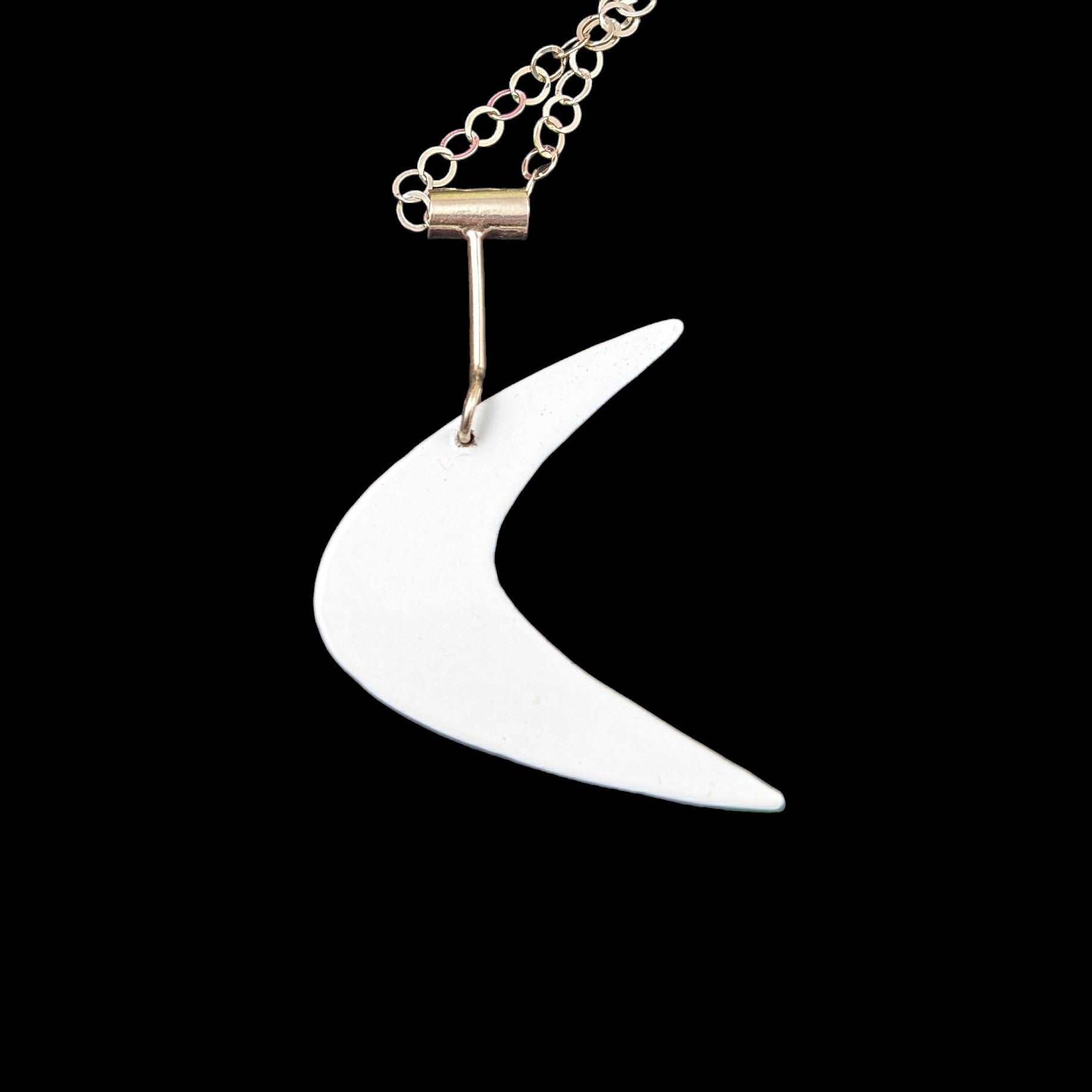 Mid mod inspired boomerang necklace in powdercoated brass and sterling silver in the color white