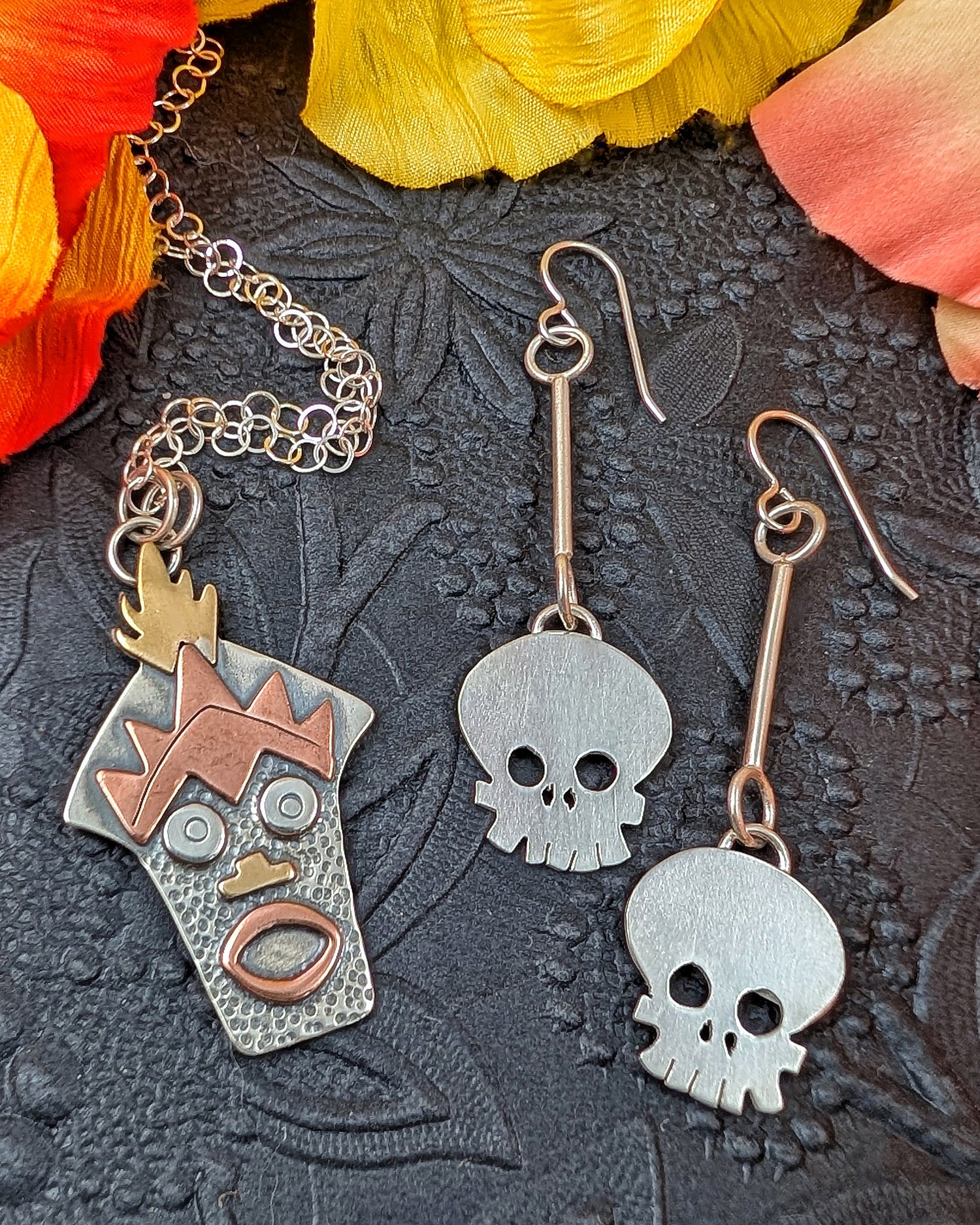 Witch Doctor with Hawaiian mask necklace and skull earrings on a black background