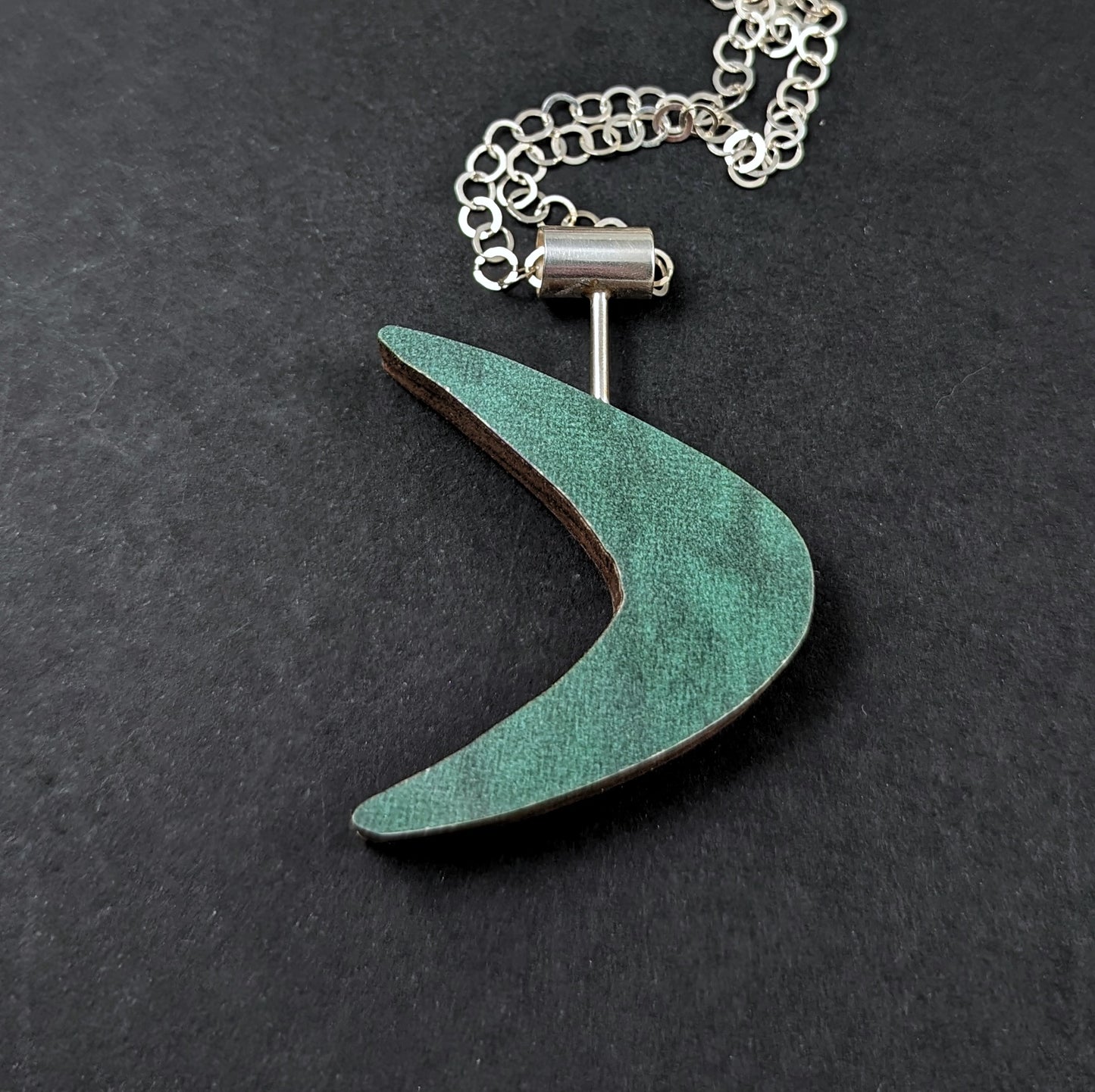 The reverse side of a Boomerang shaped laminate on wood necklace