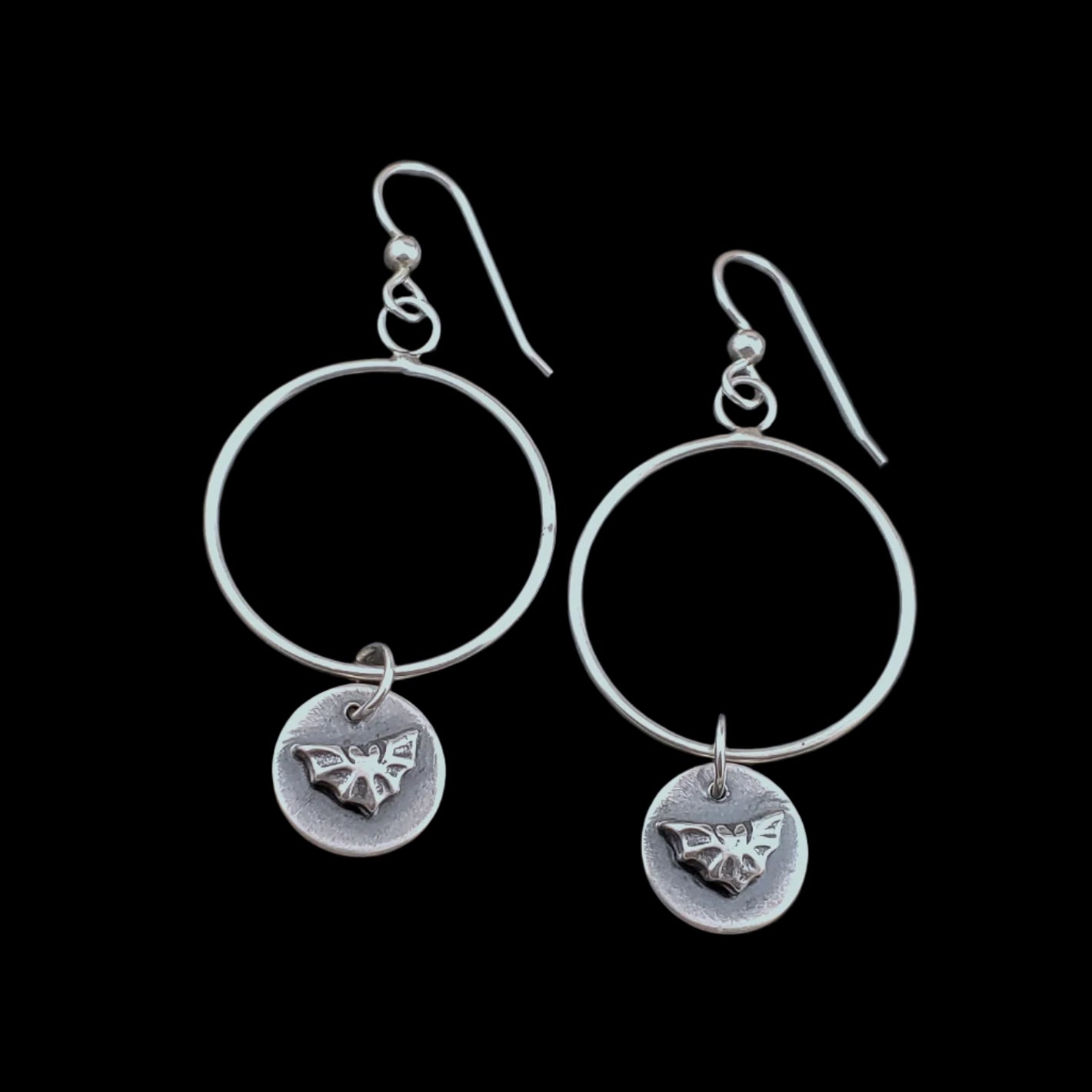 Photo of sterling silver hoops with small bat dangles.