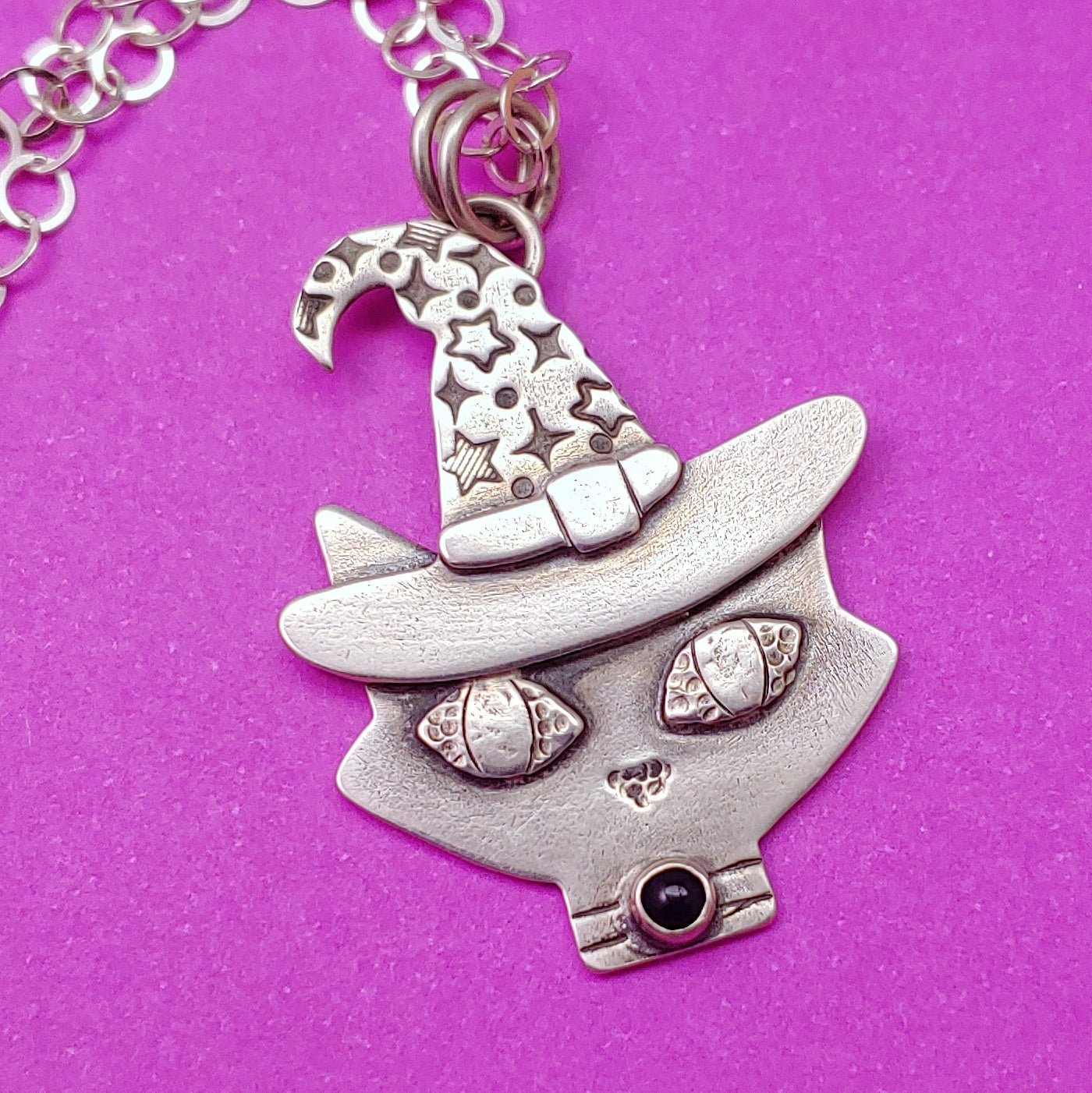 Mid century modern cat with wizard hat and black onyx stone on magenta background.