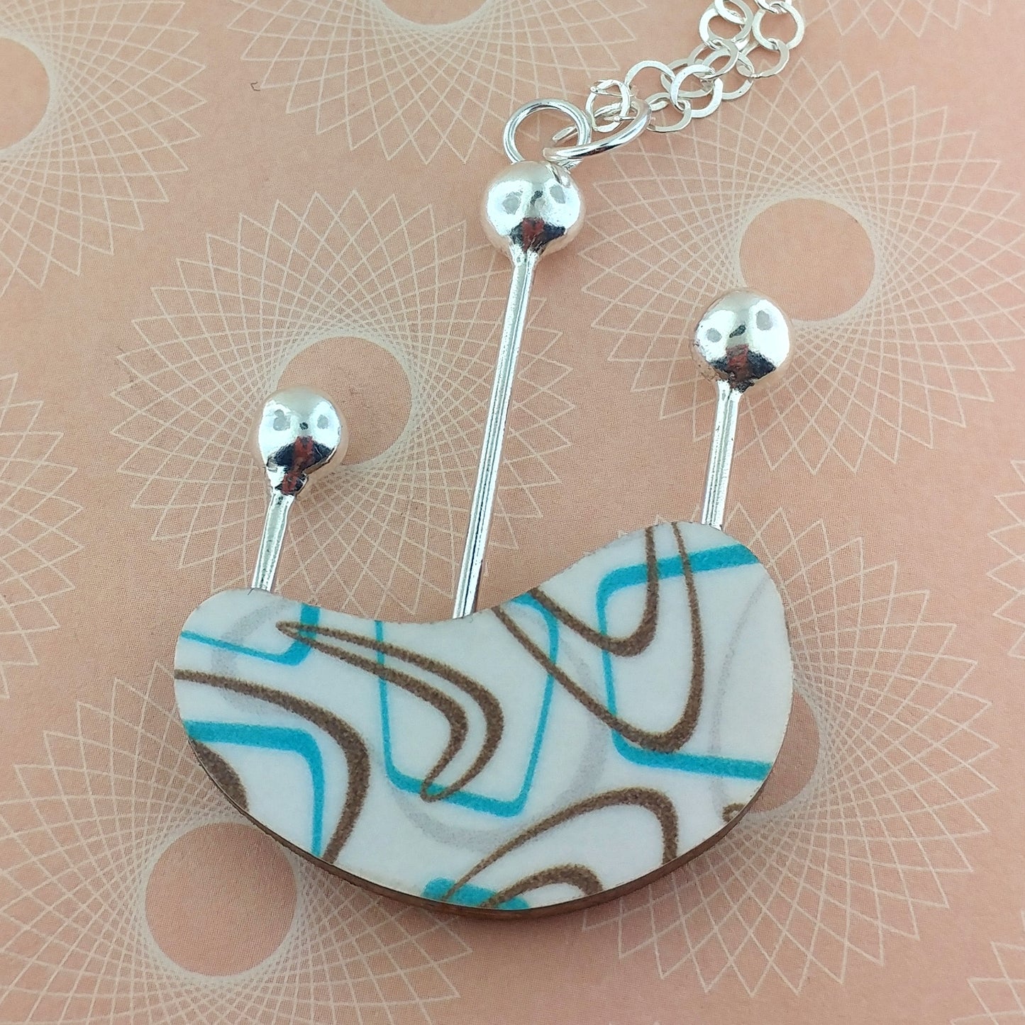 A fun, unique boomerang on laminate kidney shaped necklace