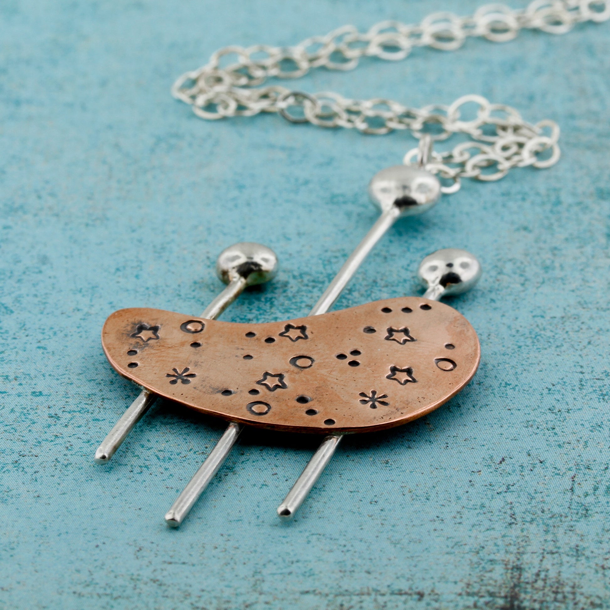 Abstract kidney shaped copper and sterling silver necklace with a modernist flair