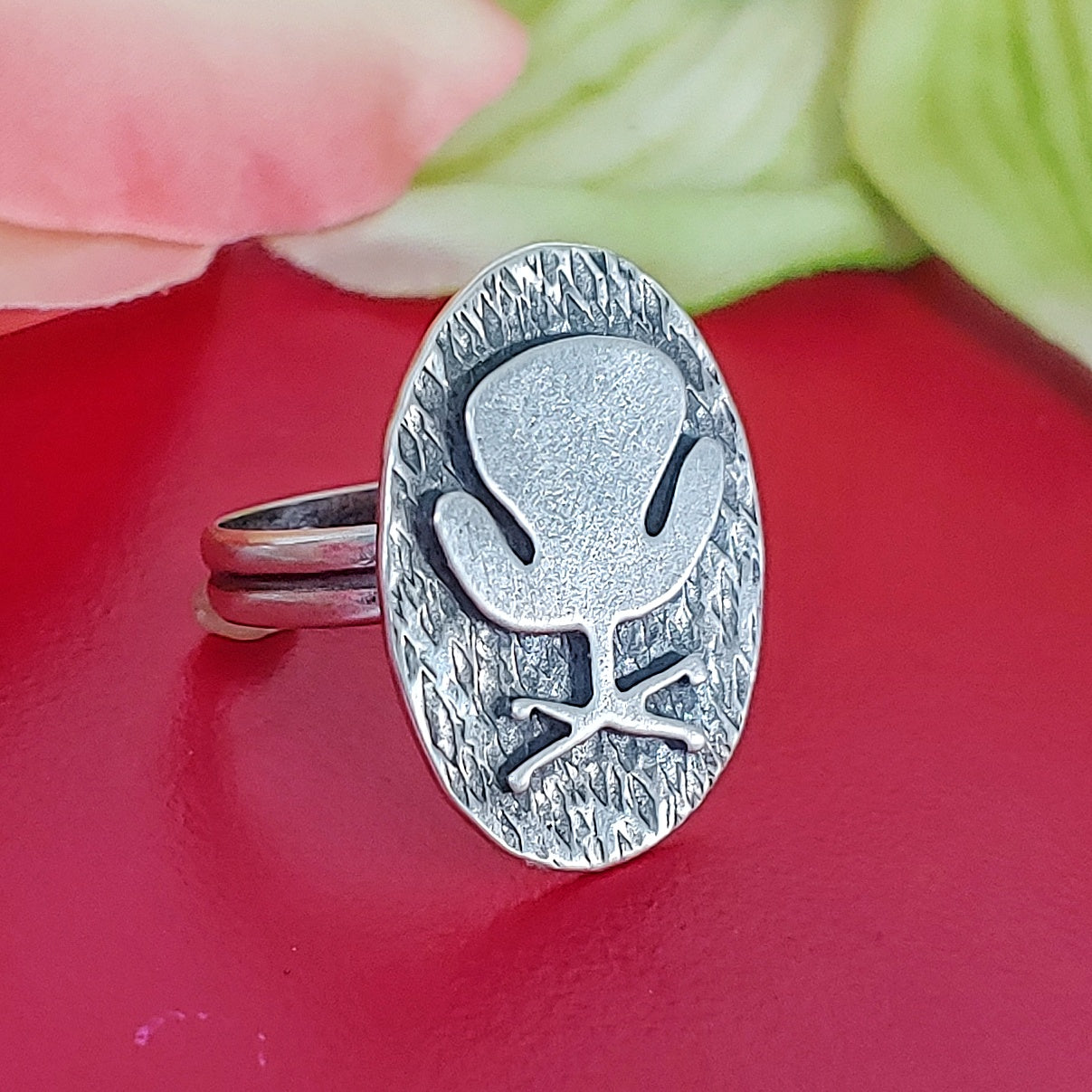 Mid century modern Swan Chair ring handmade in sterling silver which is perfect as a 17th wedding anniversary gift of furniture as shown on a red background