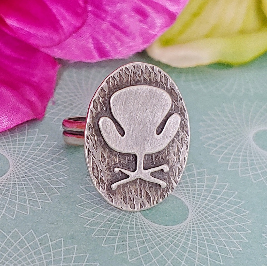 Mid century modern Swan Chair ring handmade in sterling silver which is perfect as a 17th wedding anniversary gift of furniture as shown on a light blue background
