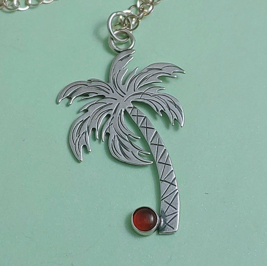 Sterling silver palm tree necklace with a carnelian coconut