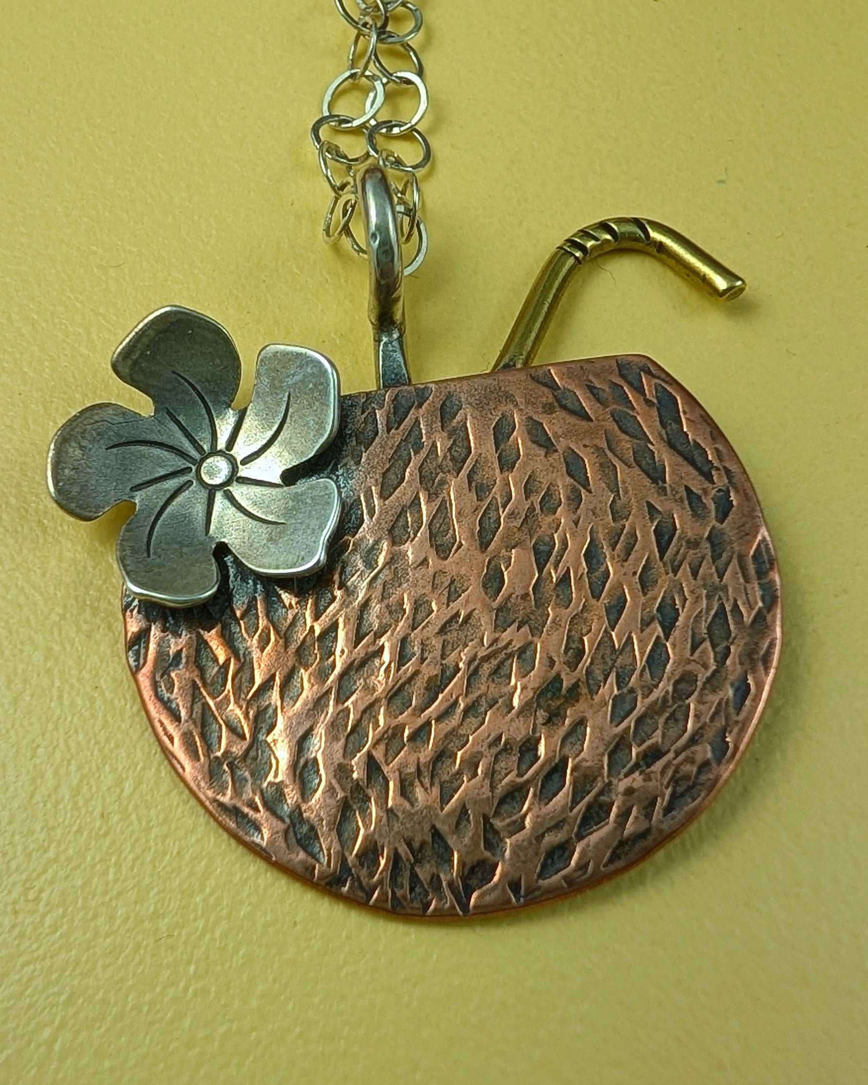 Copper coconut Tiki drink necklace on a yellow background