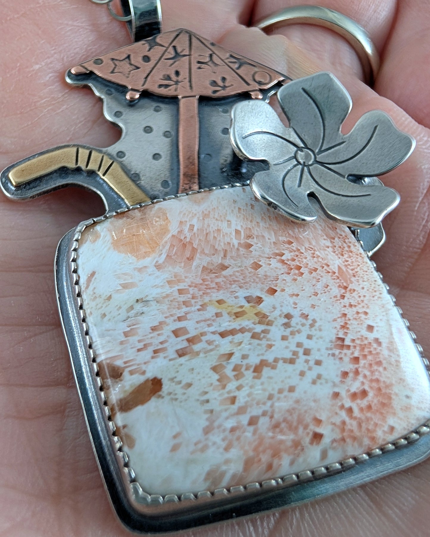 Close up of scolecite necklace Tiki cocktaail with copper umbrella and brass straw with a sterling silver chain