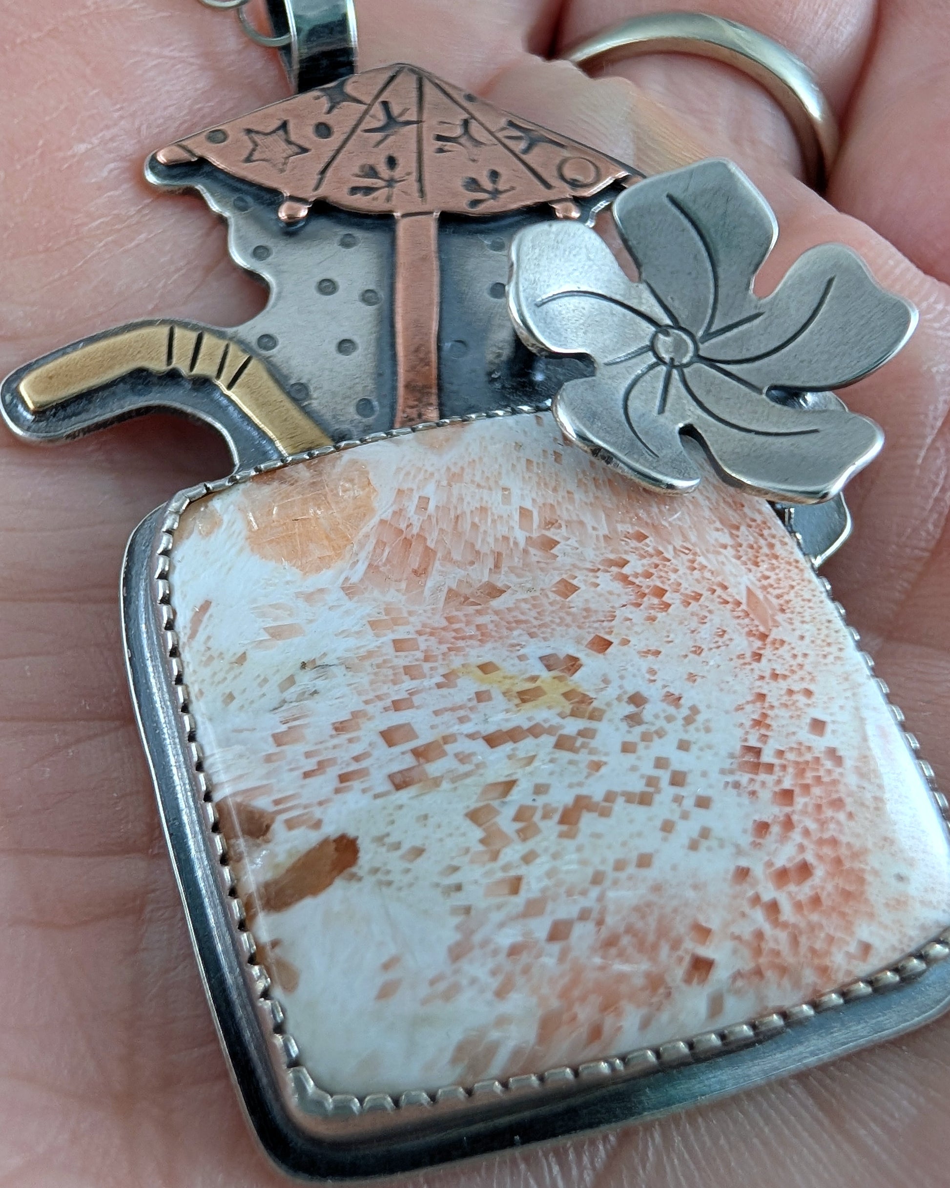 Close up of scolecite necklace Tiki cocktaail with copper umbrella and brass straw with a sterling silver chain