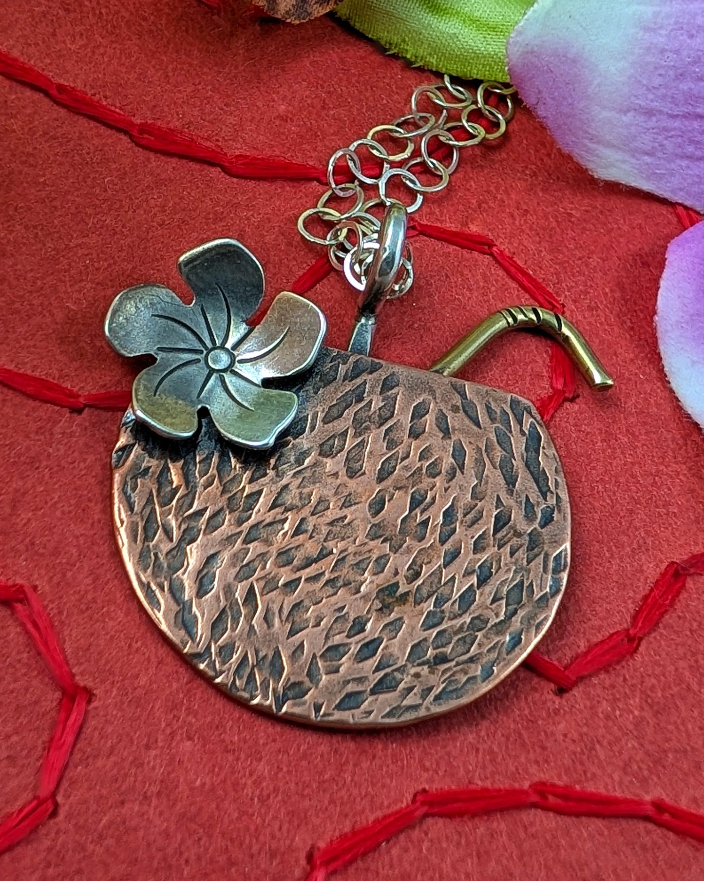 Copper coconut Tiki drink necklace on a red background