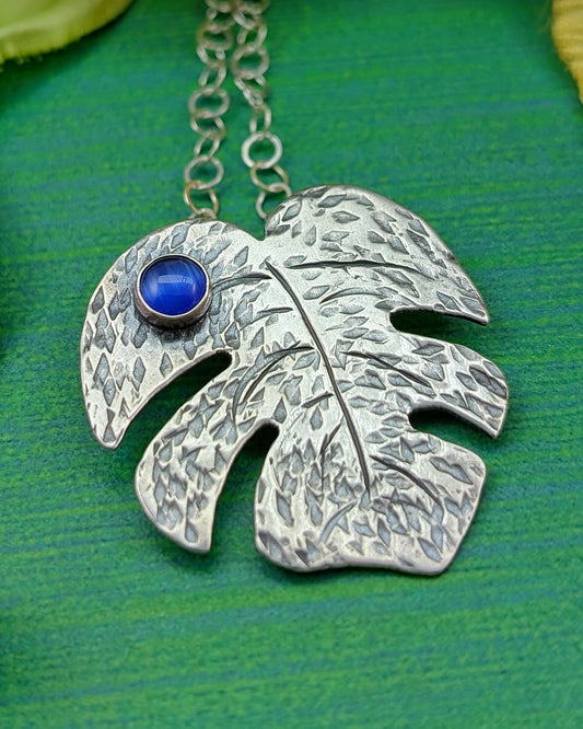 Sterling silver monstera leaf necklace with blue cat's eye