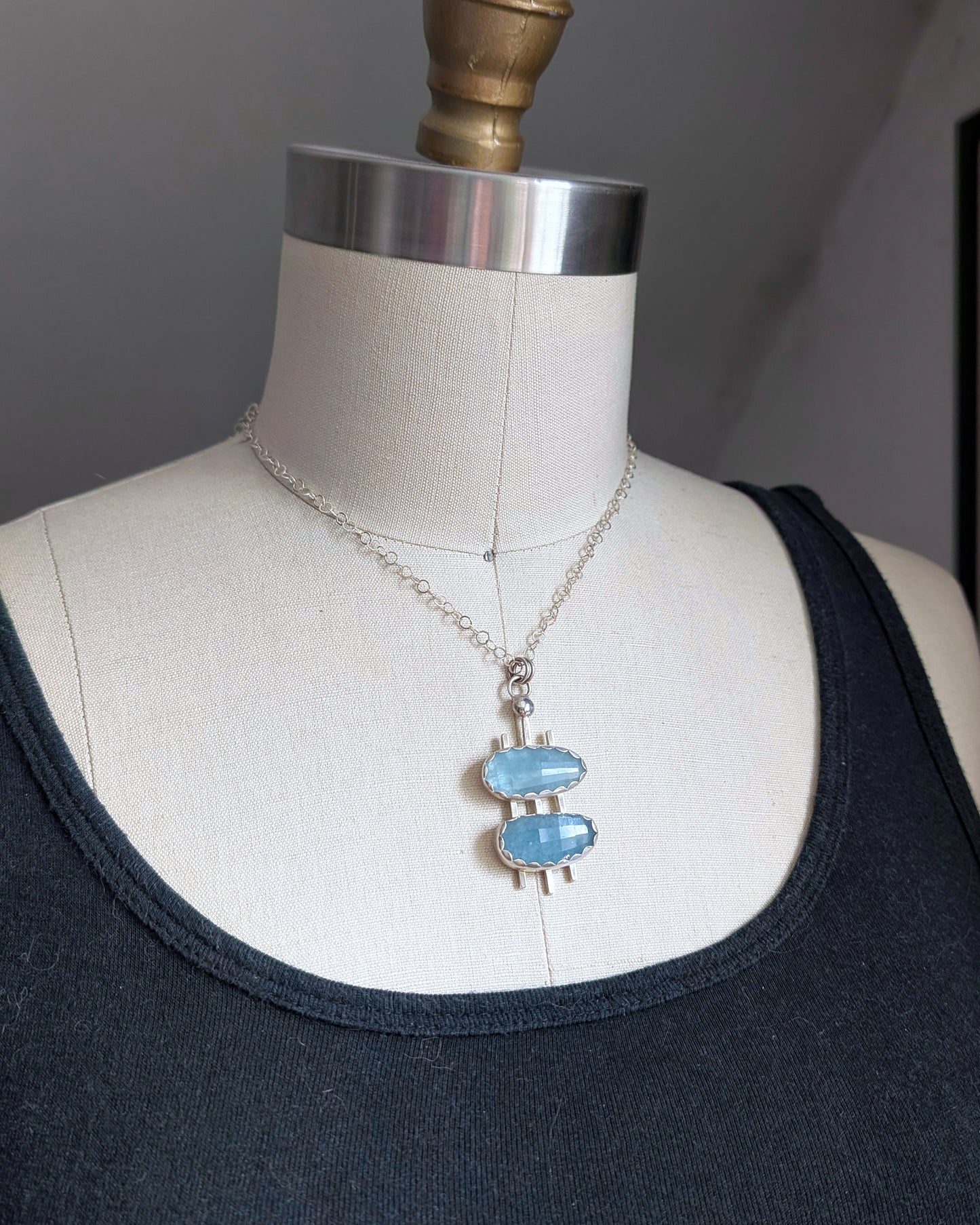 ouble decker oval necklace in sterling silver with rosecut aquamarine stones on a dress form bust