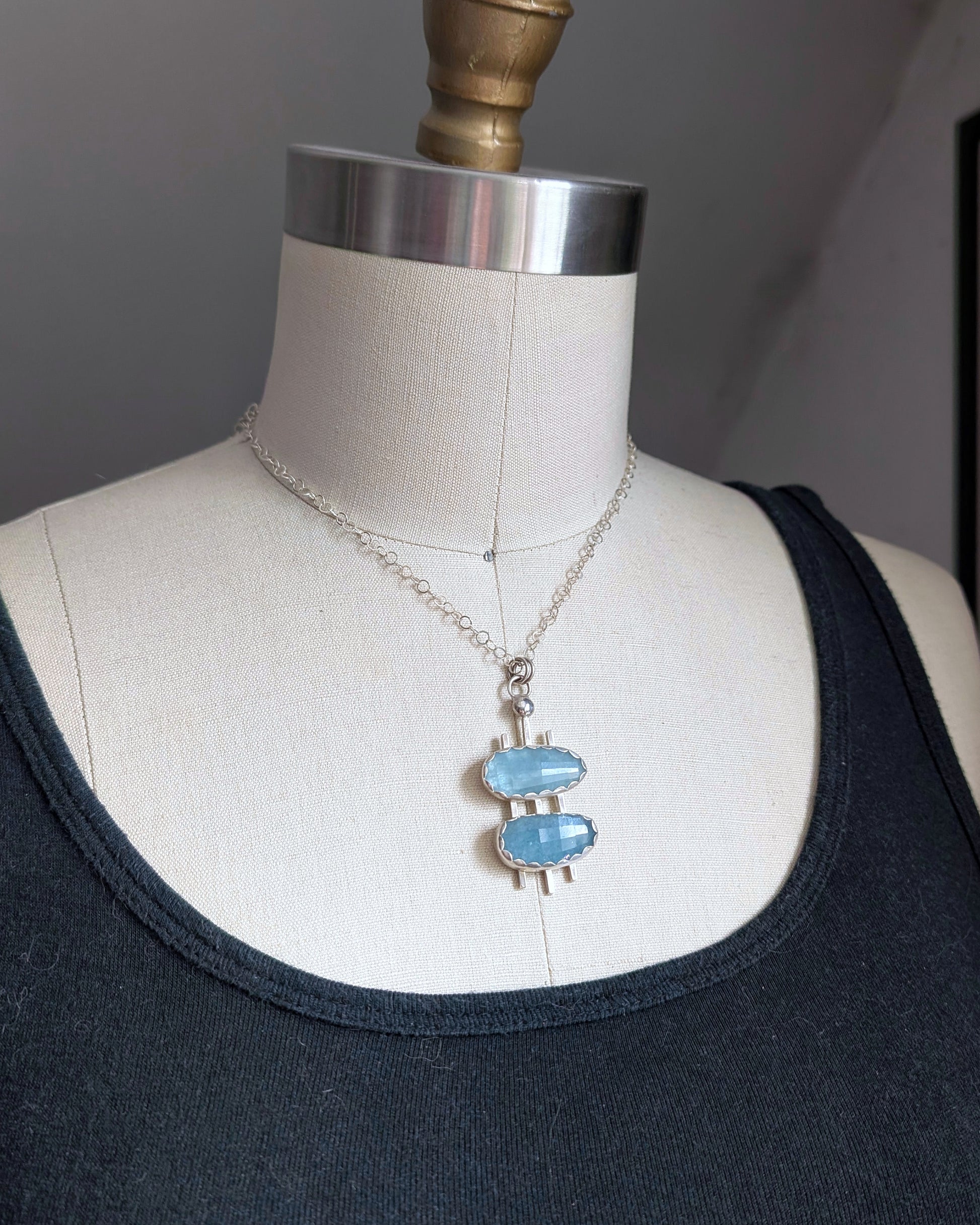 ouble decker oval necklace in sterling silver with rosecut aquamarine stones on a dress form bust