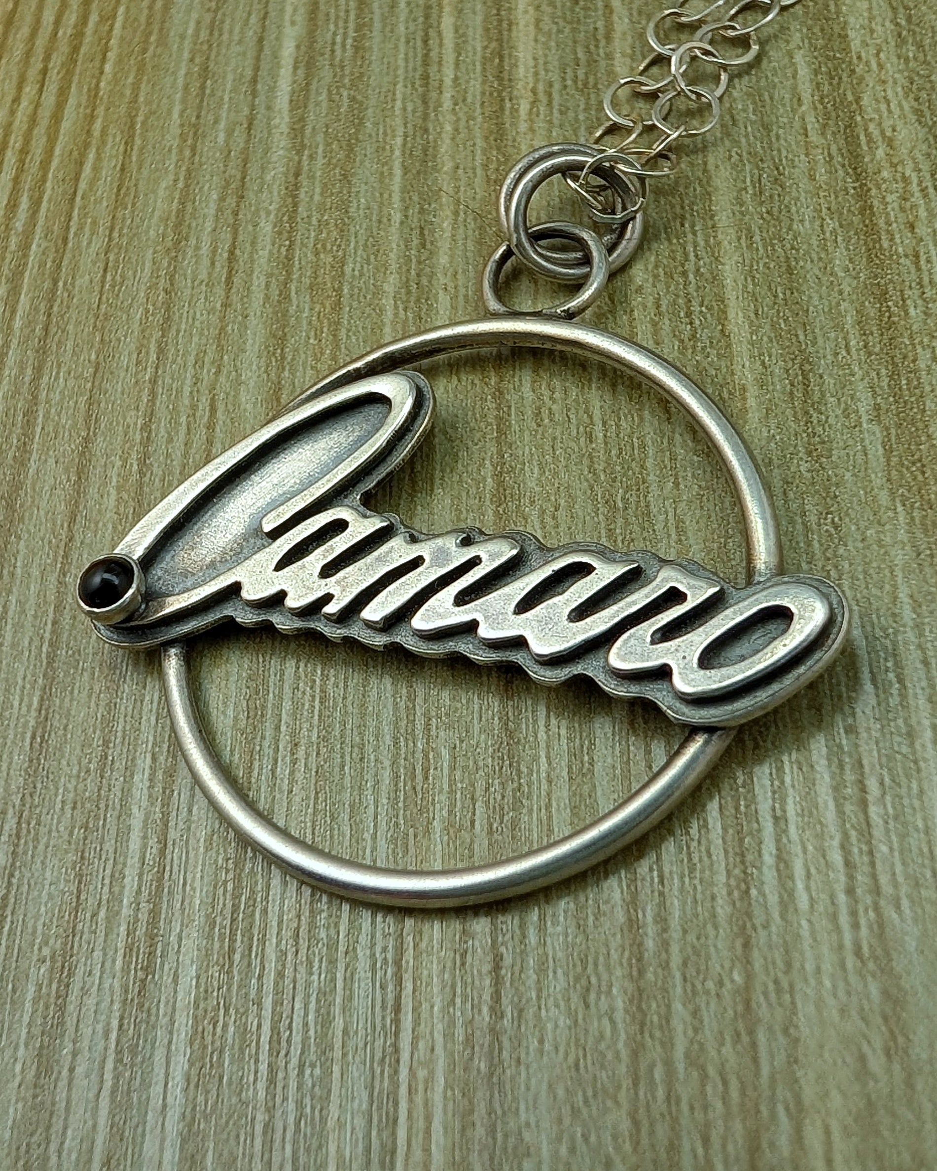 Camaro necklace with onyx on a green background