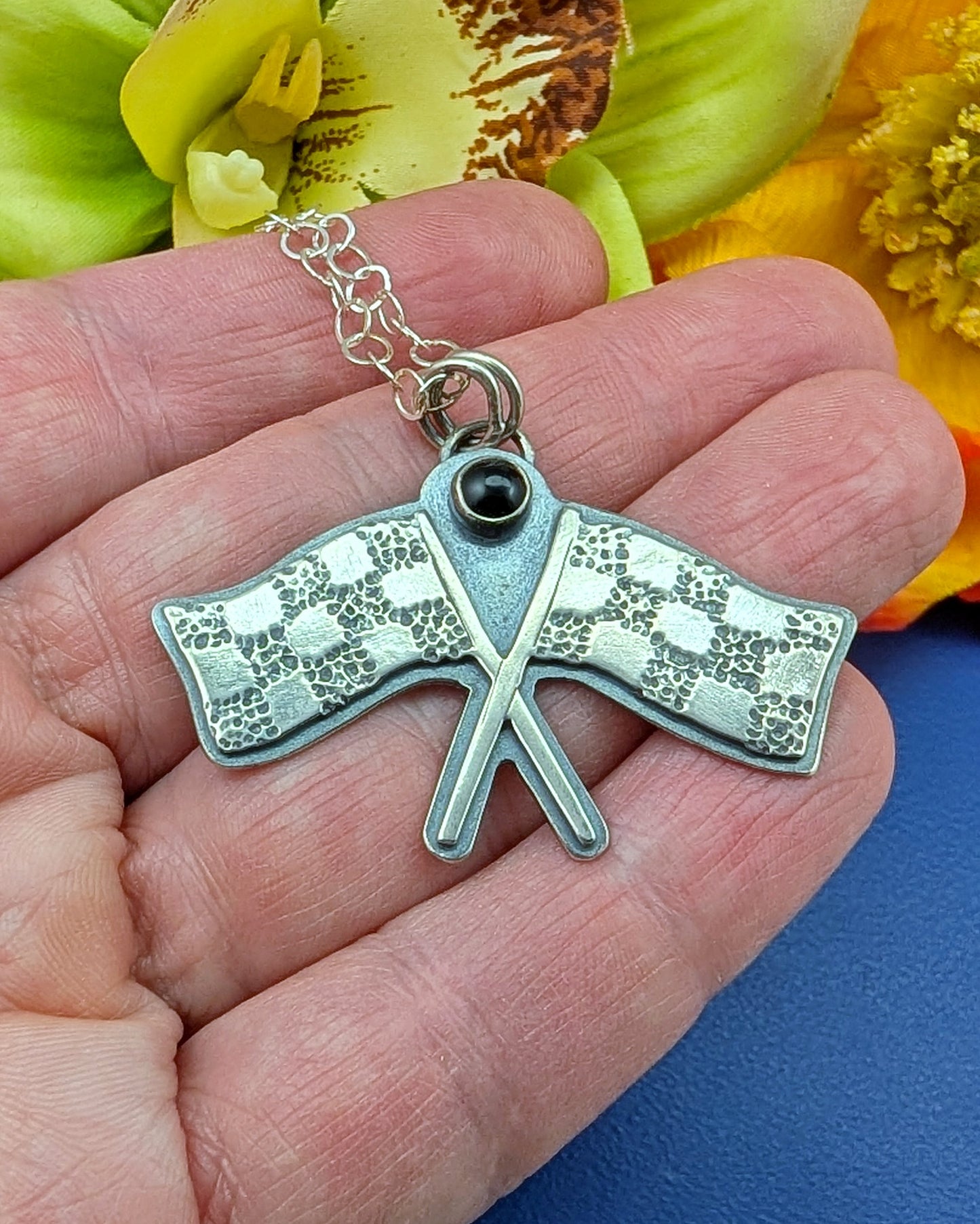 Racing flags necklace on black background