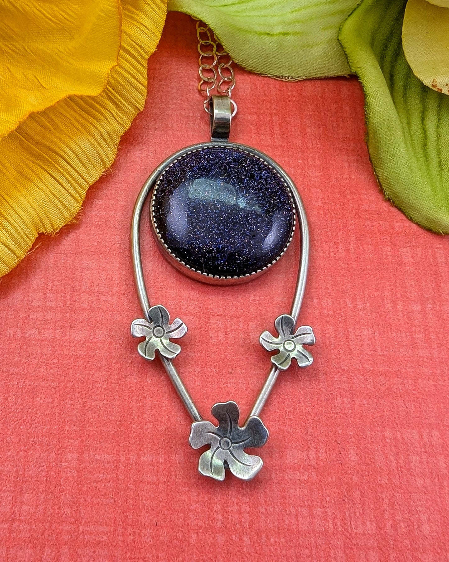 Sterling silver plumeria flowers with blue goldstone necklace on orange background