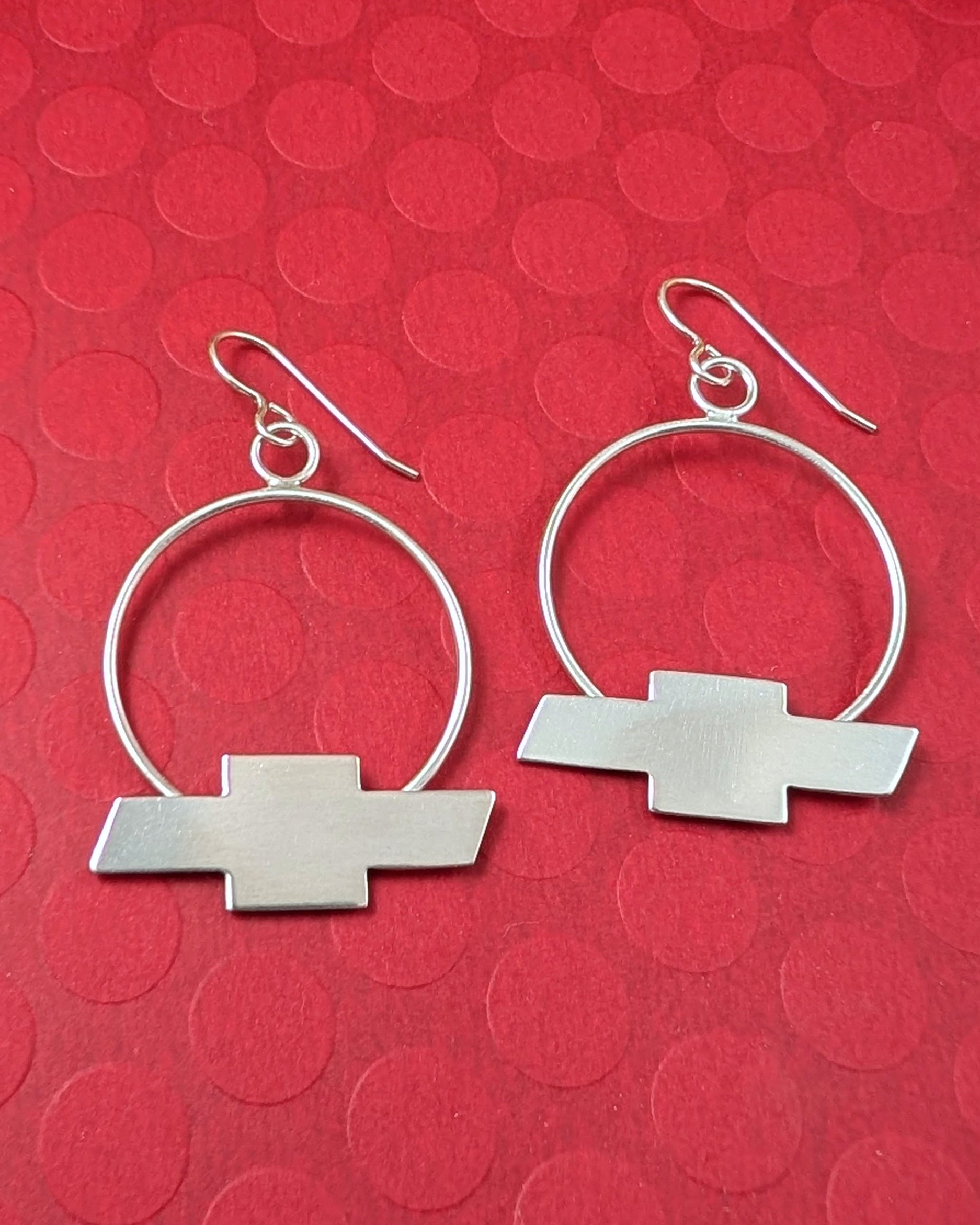 Chevrolet bow tie earrings on a red background