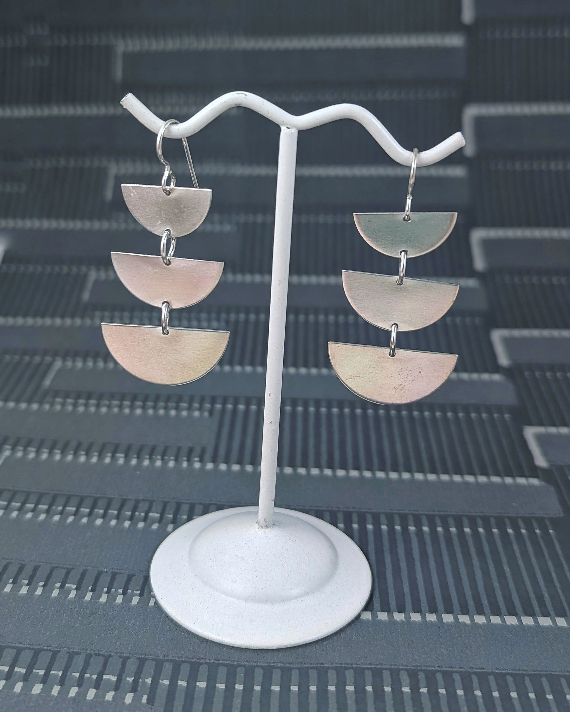 Sterling silver half moon dangle earrings on an earring stand